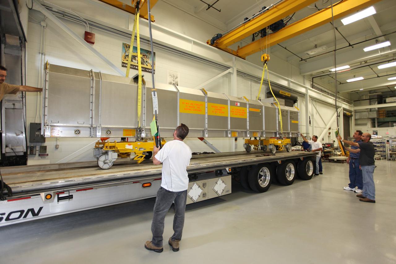 CAPE CANAVERAL, Fla. - Inside the Vehicle Assembly Building at NASA’s Kennedy Space Center in Florida, United Space Alliance workers monitor the progress as the container holding the remote manipulator system, or RMS, is lowered onto a flatbed truck for shipment back to the Canadian Space Agency. The RMS, also called the Canadarm, was manufactured for NASA’s Space Shuttle Program by SPAR Aerospace Ltd., which later became a part of MD Robotics in Ontario, Canada. During shuttle missions, the RMS was attached in the payload bay. Mission specialists operated the arm to remove payloads from the payload bay and hand them off to the larger Canadarm 2 on the International Space Station. The shuttle arm also was used during astronaut spacewalks. Photo credit: NASA/Kim Shiflett