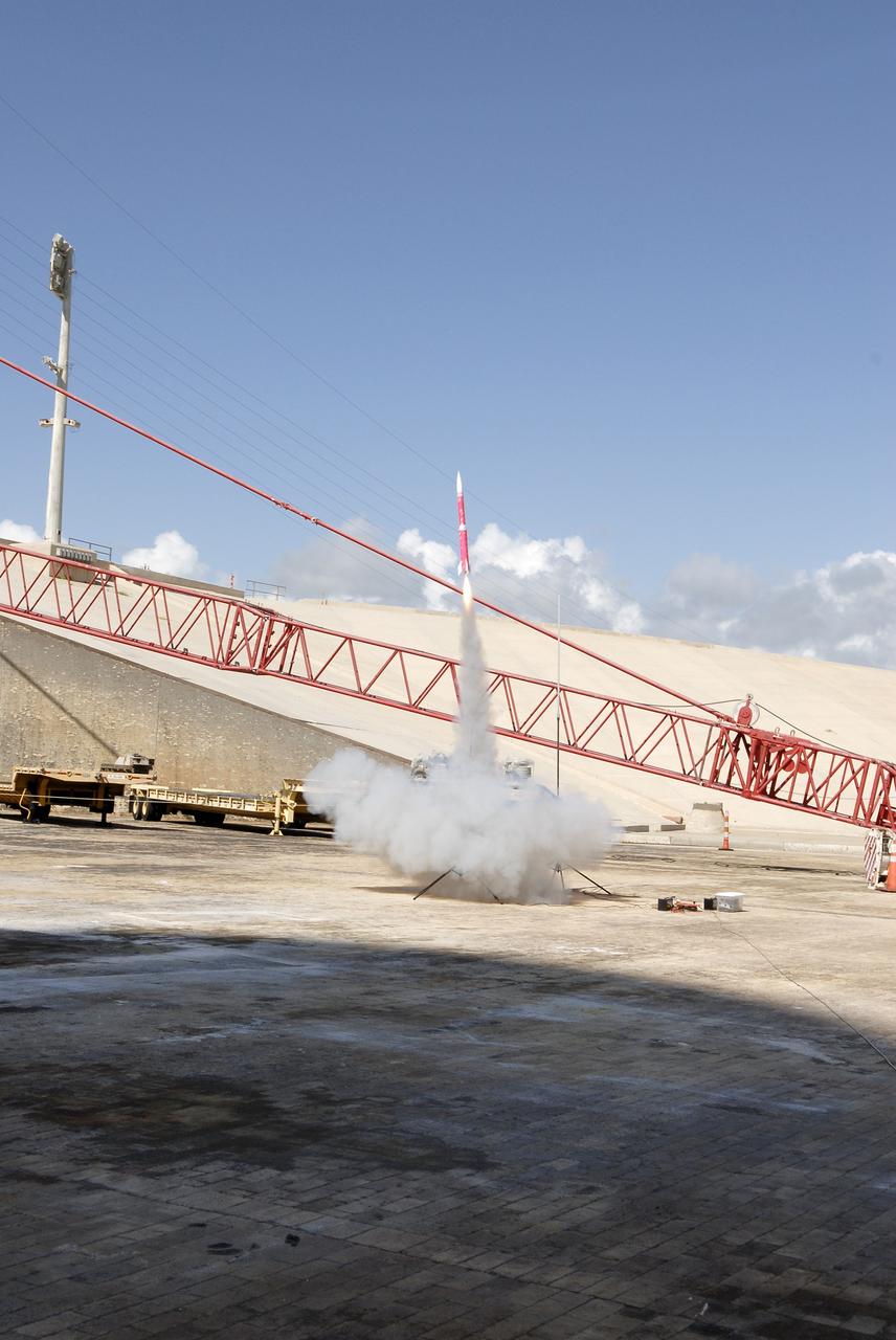 CAPE CANAVERAL, Fla. – A model rocket built by students of the International Space University launches during the rocket launch competition of the ISU's summer session. The competition was conducted at Launch Complex 39A at NASA's Kennedy Space Center in Florida, which co-hosted this year's ISU. Six teams designed and built large model rockets, each between three and five feet tall, and launched them from Launch Pad 39A, the starting point for Apollo missions to the moon and dozens of space shuttle flights. Each launch carried a raw egg, dubbed "eggstronauts" and had to recover it intact to be declared successful. Photo credit: NASA/Charisse Nahsser