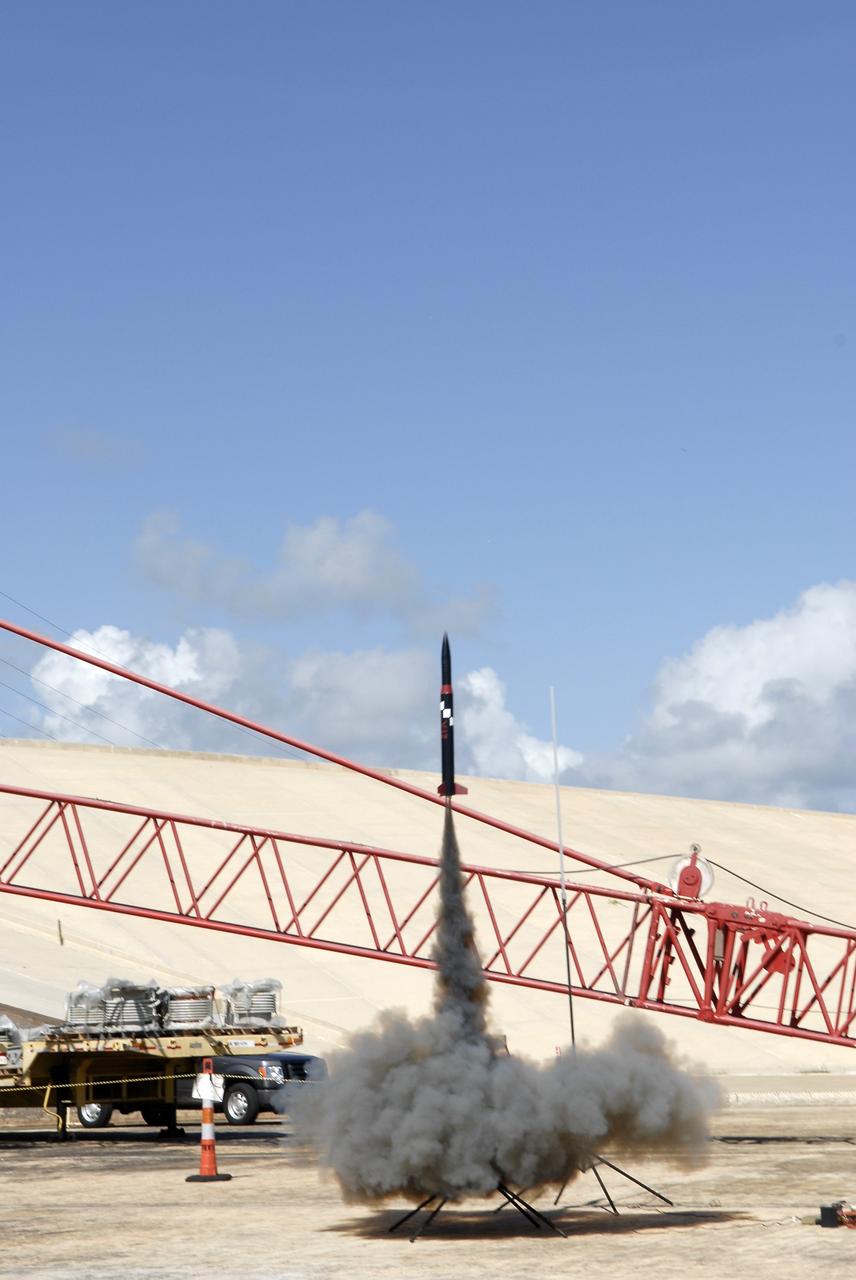 CAPE CANAVERAL, Fla. – A model rocket built by students of the International Space University launches during the rocket launch competition of the ISU's summer session. The competition was conducted at Launch Complex 39A at NASA's Kennedy Space Center in Florida, which co-hosted this year's ISU. Six teams designed and built large model rockets, each between three and five feet tall, and launched them from Launch Pad 39A, the starting point for Apollo missions to the moon and dozens of space shuttle flights. Each launch carried a raw egg, dubbed "eggstronauts" and had to recover it intact to be declared successful. Photo credit: NASA/Charisse Nahsser