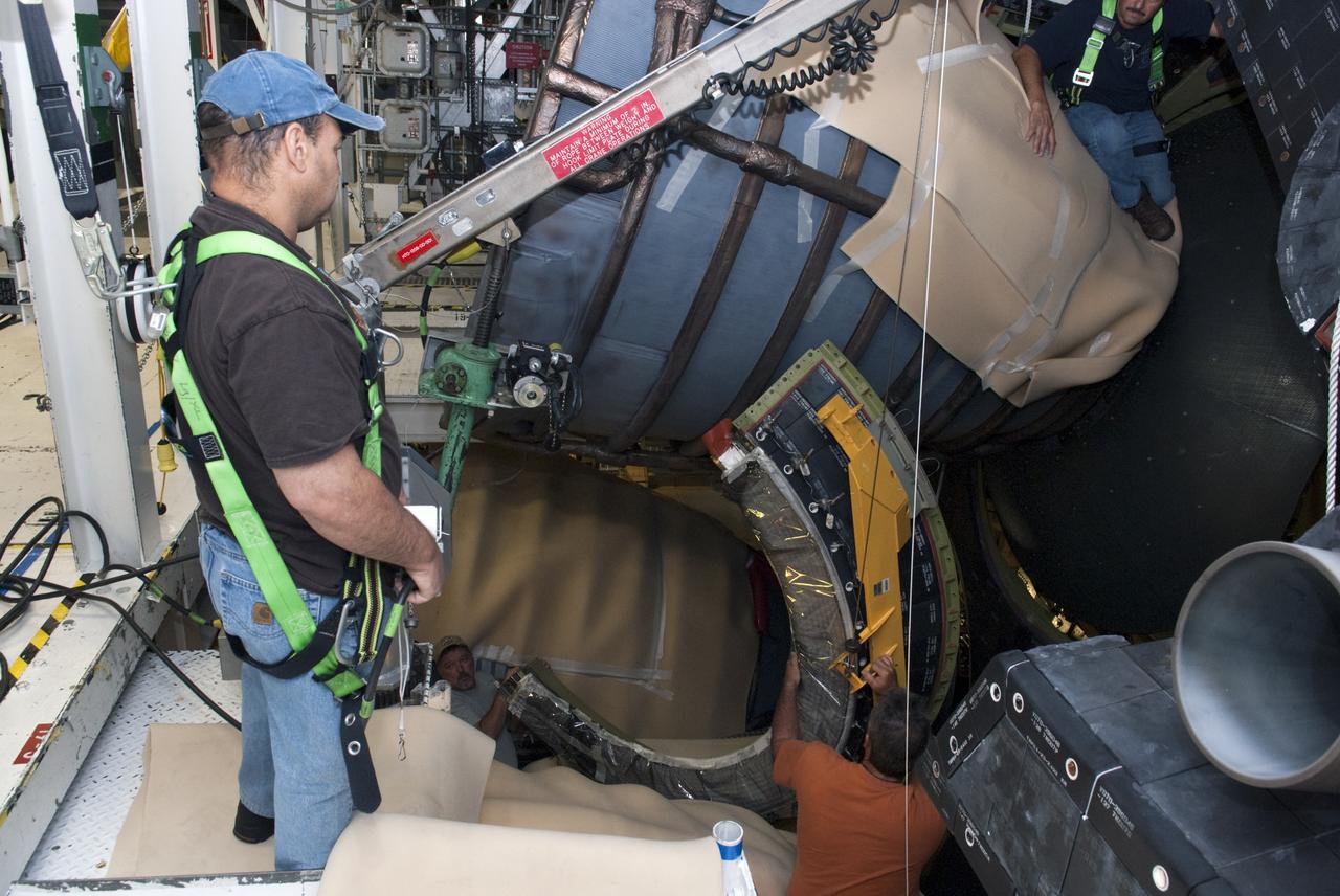 CAPE CANAVERAL, Fla. – In Orbiter Processing Facility Bay 2 at NASA’s Kennedy Space Center in Florida, United Space Alliance aerospace technicians install a heat shield around the base of space shuttle Endeavour’s replica shuttle main engine RSME number 1. Bill Ward Jr., wearing a safety harness, monitors the work of Tim Seymour in the lower portion of the image and Chris Peluso, above.      The work is part of Transition and Retirement of the remaining space shuttles, Endeavour and Atlantis. Endeavour is being prepared for public display at the California Science Center in Los Angeles. Its ferry flight to California is targeted for mid-September. Endeavour was the last space shuttle added to NASA’s orbiter fleet. Over the course of its 19-year career, Endeavour spent 299 days in space during 25 missions. For more information, visit http://www.nasa.gov/transition Photo credit: NASA/ Tim Jacobs