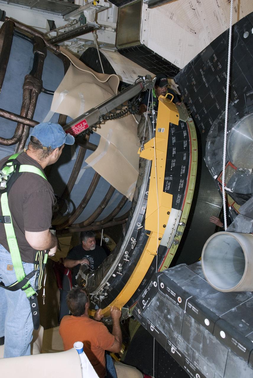 CAPE CANAVERAL, Fla. – In Orbiter Processing Facility Bay 2 at NASA’s Kennedy Space Center in Florida, United Space Alliance aerospace technicians install a heat shield around the base of space shuttle Endeavour’s replica shuttle main engine RSME number 1. Bill Ward Jr., wearing a safety harness, monitors the work of Mark Linthicum, facing the camera, and Tim Seymour.      The work is part of Transition and Retirement of the remaining space shuttles, Endeavour and Atlantis. Endeavour is being prepared for public display at the California Science Center in Los Angeles. Its ferry flight to California is targeted for mid-September. Endeavour was the last space shuttle added to NASA’s orbiter fleet. Over the course of its 19-year career, Endeavour spent 299 days in space during 25 missions. For more information, visit http://www.nasa.gov/transition Photo credit: NASA/ Tim Jacobs