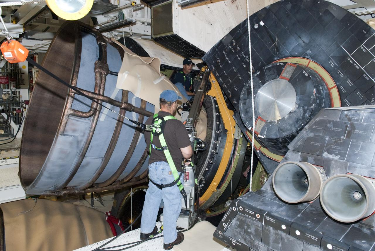 CAPE CANAVERAL, Fla. – In Orbiter Processing Facility Bay 2 at NASA’s Kennedy Space Center in Florida, United Space Alliance aerospace technicians install a heat shield around the base of space shuttle Endeavour’s replica shuttle main engine RSME number 1. Bill Ward Jr., wearing a safety harness and his back to the camera, assists Chris Peluso.      The work is part of Transition and Retirement of the remaining space shuttles, Endeavour and Atlantis. Endeavour is being prepared for public display at the California Science Center in Los Angeles. Its ferry flight to California is targeted for mid-September. Endeavour was the last space shuttle added to NASA’s orbiter fleet. Over the course of its 19-year career, Endeavour spent 299 days in space during 25 missions. For more information, visit http://www.nasa.gov/transition Photo credit: NASA/ Tim Jacobs