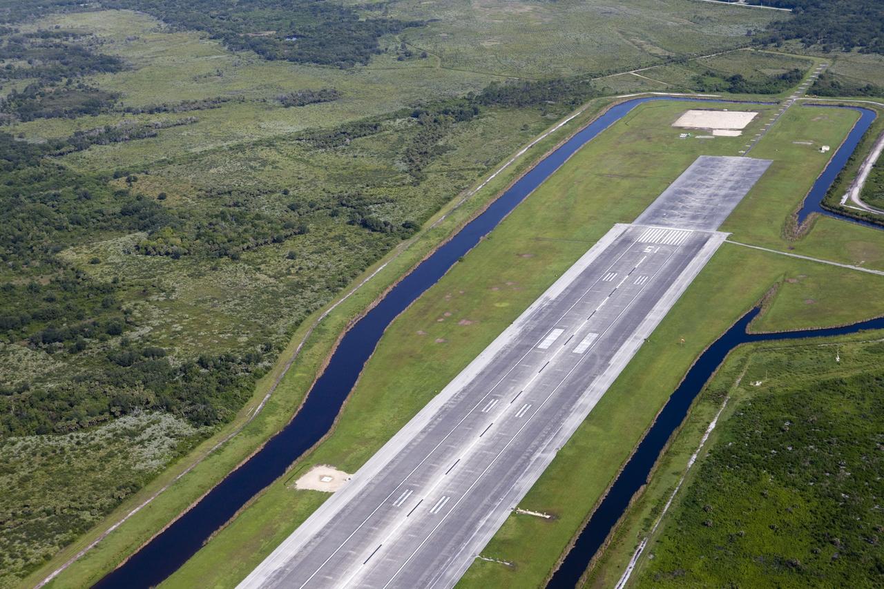 CAPE CANAVERAL, Fla. – This aerial view shows the north end of the Kennedy Space Center’s Shuttle Landing Facility. At the end of the runway, in the upper right, a rock and crater-filled planetary scape has been built so engineers can test the Autonomous Landing and Hazard Avoidance Technology, or ALHAT system on the Project Morpheus lander. Testing will demonstrate ALHAT’s ability to provide required navigation data negotiating the Morpheus lander away from risks during descent. Checkout of the prototype lander has been ongoing at NASA’s Johnson Space Center in Houston in preparation for its first free flight. The SLF site will provide the lander with the kind of field necessary for realistic testing. Project Morpheus is one of 20 small projects comprising the Advanced Exploration Systems, or AES, program in NASA’s Human Exploration and Operations Mission Directorate. AES projects pioneer new approaches for rapidly developing prototype systems, demonstrating key capabilities and validating operational concepts for future human missions beyond Earth orbit. For more information on Project Morpheus, visit http://www.nasa.gov/centers/johnson/exploration/morpheus/index.html Photo credit: NASA/Kim Shiflett