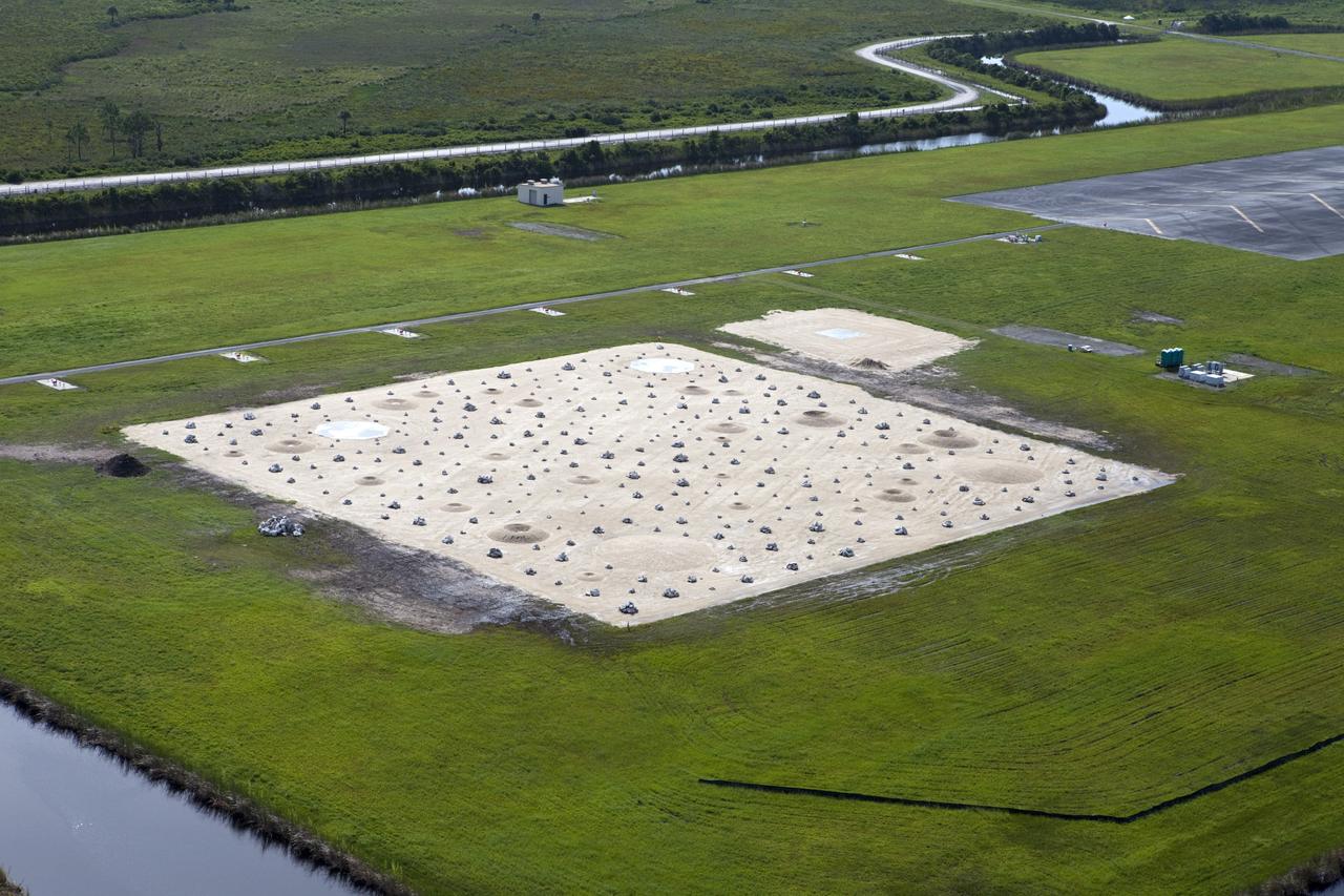 CAPE CANAVERAL, Fla. –This aerial view shows a rock and crater-filled planetary scape that has been built at the north end of the Kennedy Space Center’s Shuttle Landing Facility. The site will allow engineers to test the Autonomous Landing and Hazard Avoidance Technology, or ALHAT system on the Project Morpheus lander. Testing will demonstrate ALHAT’s ability to provide required navigation data negotiating the Morpheus lander away from risks during descent. Checkout of the prototype lander has been ongoing at NASA’s Johnson Space Center in Houston in preparation for its first free flight. The SLF site will provide the lander with the kind of field necessary for realistic testing. Project Morpheus is one of 20 small projects comprising the Advanced Exploration Systems, or AES, program in NASA’s Human Exploration and Operations Mission Directorate. AES projects pioneer new approaches for rapidly developing prototype systems, demonstrating key capabilities and validating operational concepts for future human missions beyond Earth orbit. For more information on Project Morpheus, visit http://www.nasa.gov/centers/johnson/exploration/morpheus/index.html Photo credit: NASA/Kim Shiflett
