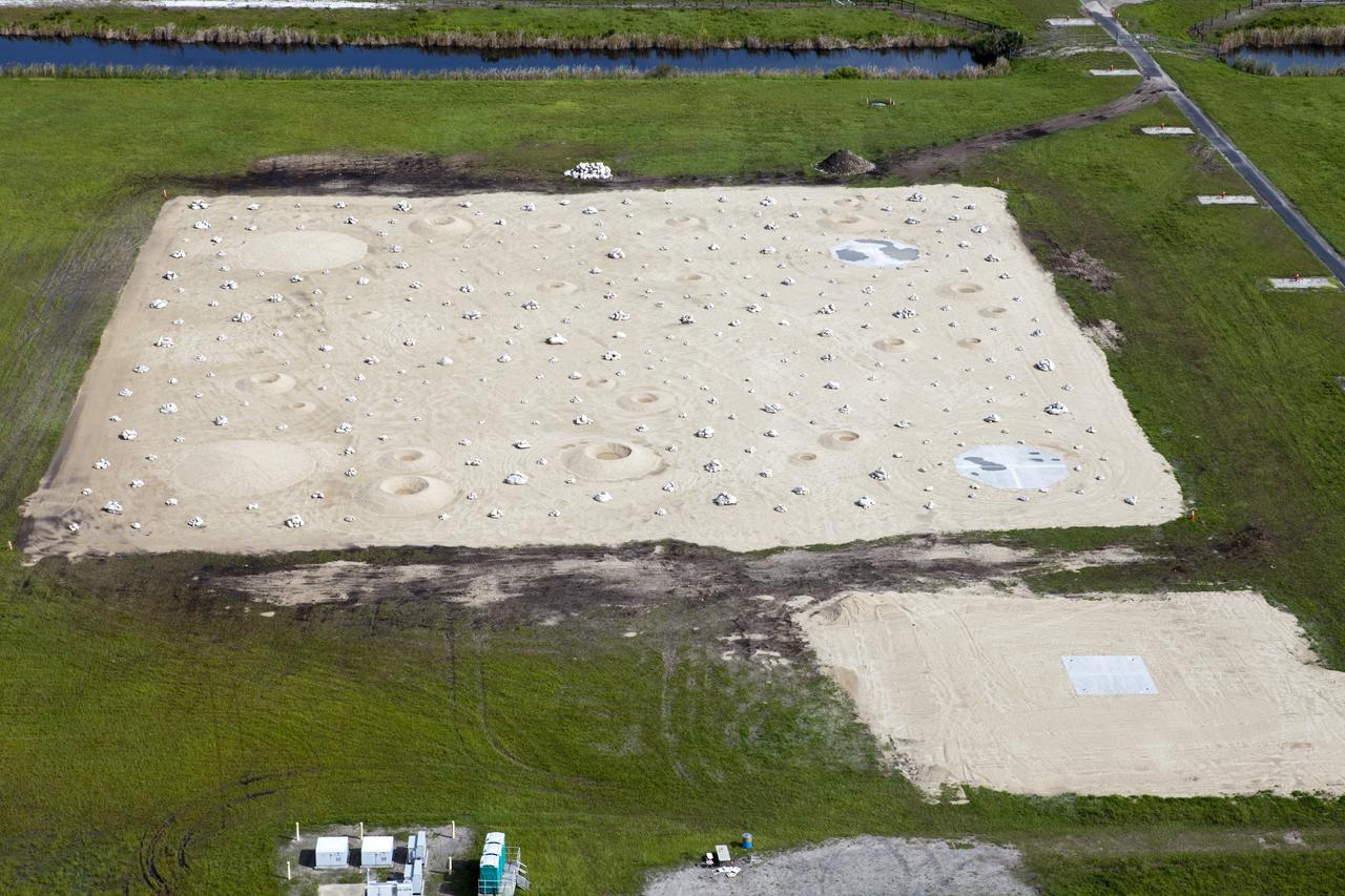 CAPE CANAVERAL, Fla. – This aerial view shows a rock and crater-filled planetary scape that has been built at the north end of the Kennedy Space Center’s Shuttle Landing Facility. The site will allow engineers to test the Autonomous Landing and Hazard Avoidance Technology, or ALHAT system on the Project Morpheus lander. Testing will demonstrate ALHAT’s ability to provide required navigation data negotiating the Morpheus lander away from risks during descent. Checkout of the prototype lander has been ongoing at NASA’s Johnson Space Center in Houston in preparation for its first free flight. The SLF site will provide the lander with the kind of field necessary for realistic testing. Project Morpheus is one of 20 small projects comprising the Advanced Exploration Systems, or AES, program in NASA’s Human Exploration and Operations Mission Directorate. AES projects pioneer new approaches for rapidly developing prototype systems, demonstrating key capabilities and validating operational concepts for future human missions beyond Earth orbit. For more information on Project Morpheus, visit http://www.nasa.gov/centers/johnson/exploration/morpheus/index.html Photo credit: NASA/Kim Shiflett