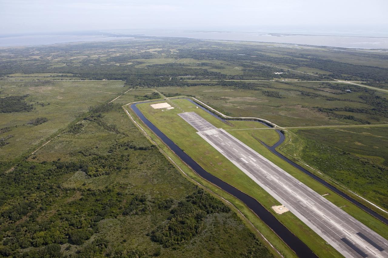 CAPE CANAVERAL, Fla. – This aerial view shows the north end of the Kennedy Space Center’s Shuttle Landing Facility. At the end of the runway is a rock and crater-filled planetary scape has been built so engineers can test the Autonomous Landing and Hazard Avoidance Technology, or ALHAT system on the Project Morpheus lander. Testing will demonstrate ALHAT’s ability to provide required navigation data negotiating the Morpheus lander away from risks during descent. Checkout of the prototype lander has been ongoing at NASA’s Johnson Space Center in Houston in preparation for its first free flight. The SLF site will provide the lander with the kind of field necessary for realistic testing. Project Morpheus is one of 20 small projects comprising the Advanced Exploration Systems, or AES, program in NASA’s Human Exploration and Operations Mission Directorate. AES projects pioneer new approaches for rapidly developing prototype systems, demonstrating key capabilities and validating operational concepts for future human missions beyond Earth orbit. For more information on Project Morpheus, visit http://www.nasa.gov/centers/johnson/exploration/morpheus/index.html Photo credit: NASA/Kim Shiflett
