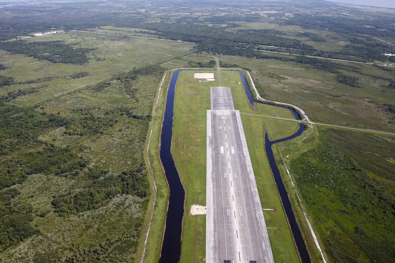 CAPE CANAVERAL, Fla. – This aerial view shows the north end of the Kennedy Space Center’s Shuttle Landing Facility. At the end of the runway is a rock and crater-filled planetary scape has been built so engineers can test the Autonomous Landing and Hazard Avoidance Technology, or ALHAT system on the Project Morpheus lander. Testing will demonstrate ALHAT’s ability to provide required navigation data negotiating the Morpheus lander away from risks during descent. Checkout of the prototype lander has been ongoing at NASA’s Johnson Space Center in Houston in preparation for its first free flight. The SLF site will provide the lander with the kind of field necessary for realistic testing. Project Morpheus is one of 20 small projects comprising the Advanced Exploration Systems, or AES, program in NASA’s Human Exploration and Operations Mission Directorate. AES projects pioneer new approaches for rapidly developing prototype systems, demonstrating key capabilities and validating operational concepts for future human missions beyond Earth orbit. For more information on Project Morpheus, visit http://www.nasa.gov/centers/johnson/exploration/morpheus/index.html Photo credit: NASA/Kim Shiflett