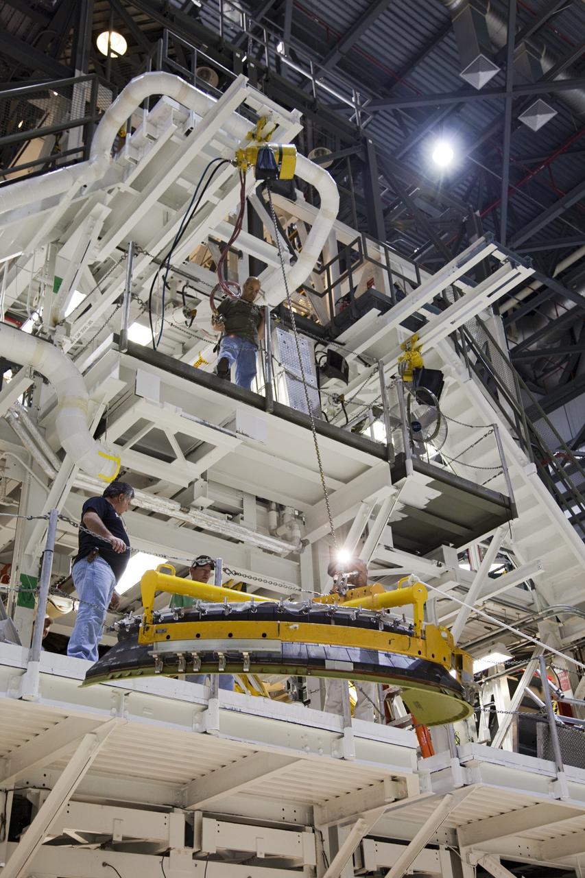 CAPE CANAVERAL, Fla. – In Orbiter Processing Facility Bay 2 at NASA’s Kennedy Space Center in Florida, United Space Alliance technicians lift a heat shield to one of the work platforms for installation around one of space shuttle Endeavour’s replica shuttle main engines.      The work is part of Transition and Retirement of the remaining space shuttles, Endeavour and Atlantis. Endeavour is being prepared for public display at the California Science Center in Los Angeles. Its ferry flight to California is targeted for mid-September. Endeavour was the last space shuttle added to NASA’s orbiter fleet. Over the course of its 19-year career, Endeavour spent 299 days in space during 25 missions. For more information, visit http://www.nasa.gov/transition Photo credit: NASA/ Frankie Martin