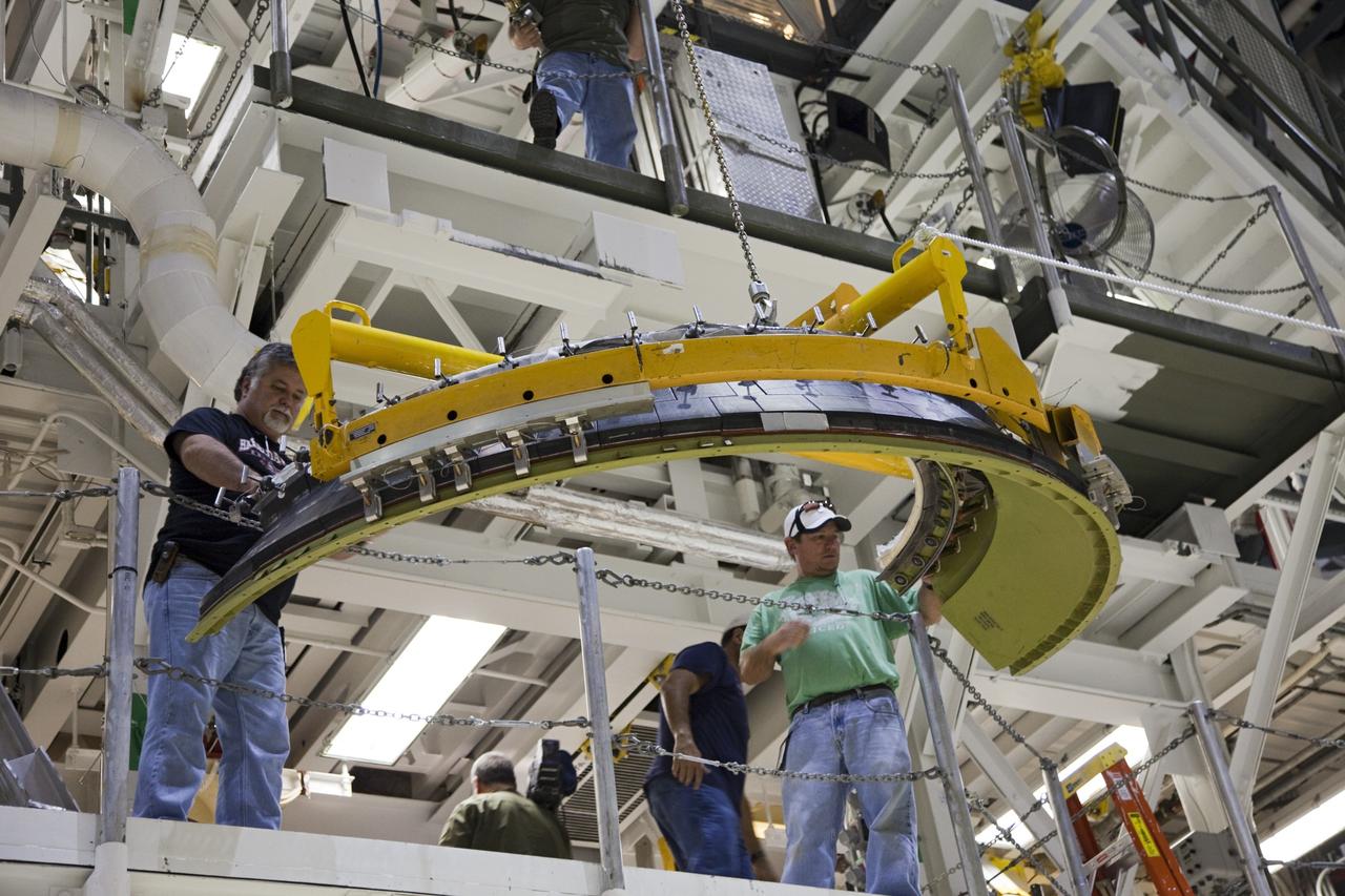 CAPE CANAVERAL, Fla. – In Orbiter Processing Facility Bay 2 at NASA’s Kennedy Space Center in Florida, United Space Alliance technicians lift a heat shield to one of the work platforms for installation around one of space shuttle Endeavour’s replica shuttle main engines.      The work is part of Transition and Retirement of the remaining space shuttles, Endeavour and Atlantis. Endeavour is being prepared for public display at the California Science Center in Los Angeles. Its ferry flight to California is targeted for mid-September. Endeavour was the last space shuttle added to NASA’s orbiter fleet. Over the course of its 19-year career, Endeavour spent 299 days in space during 25 missions. For more information, visit http://www.nasa.gov/transition Photo credit: NASA/ Frankie Martin