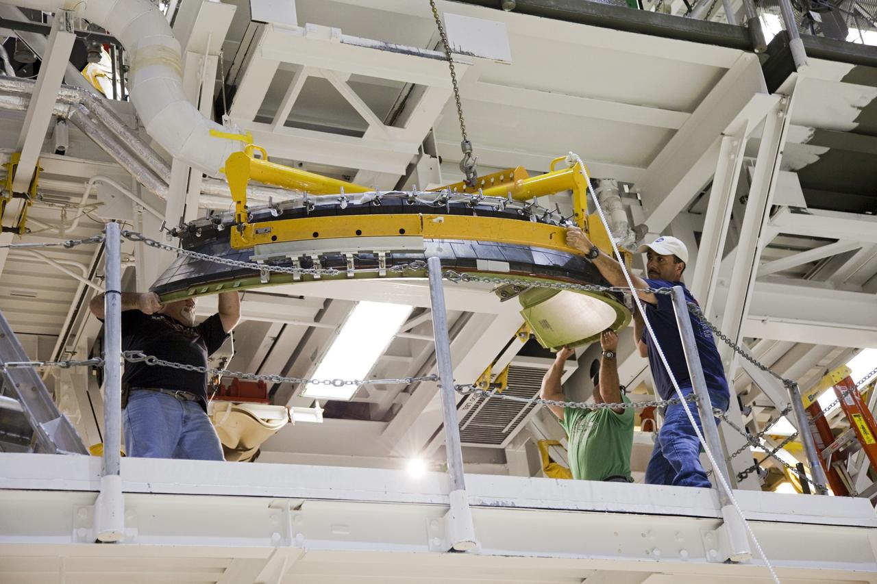 CAPE CANAVERAL, Fla. – In Orbiter Processing Facility Bay 2 at NASA’s Kennedy Space Center in Florida, United Space Alliance technicians lift a heat shield to one of the work platforms for installation around one of space shuttle Endeavour’s replica shuttle main engines.      The work is part of Transition and Retirement of the remaining space shuttles, Endeavour and Atlantis. Endeavour is being prepared for public display at the California Science Center in Los Angeles. Its ferry flight to California is targeted for mid-September. Endeavour was the last space shuttle added to NASA’s orbiter fleet. Over the course of its 19-year career, Endeavour spent 299 days in space during 25 missions. For more information, visit http://www.nasa.gov/transition Photo credit: NASA/ Frankie Martin