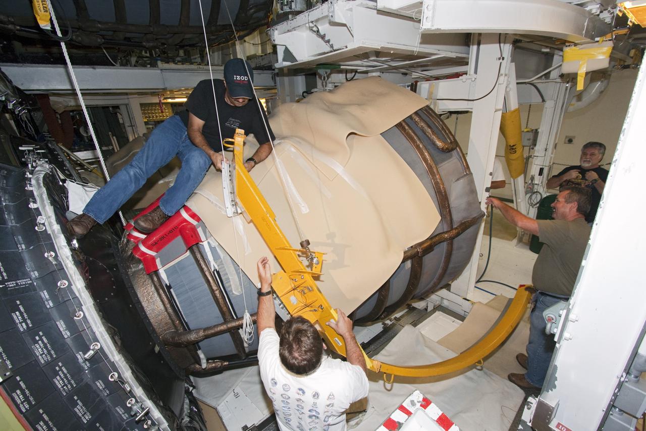 CAPE CANAVERAL, Fla. – In Orbiter Processing Facility Bay 2 at NASA’s Kennedy Space Center in Florida, United Space Alliance technicians remove ground support equipment following installation of a heat shield around one of space shuttle Endeavour’s replica shuttle main engines.      The work is part of Transition and Retirement of the remaining space shuttles, Endeavour and Atlantis. Endeavour is being prepared for public display at the California Science Center in Los Angeles. Its ferry flight to California is targeted for mid-September. Endeavour was the last space shuttle added to NASA’s orbiter fleet. Over the course of its 19-year career, Endeavour spent 299 days in space during 25 missions. For more information, visit http://www.nasa.gov/transition Photo credit: NASA/ Jim Grossmann