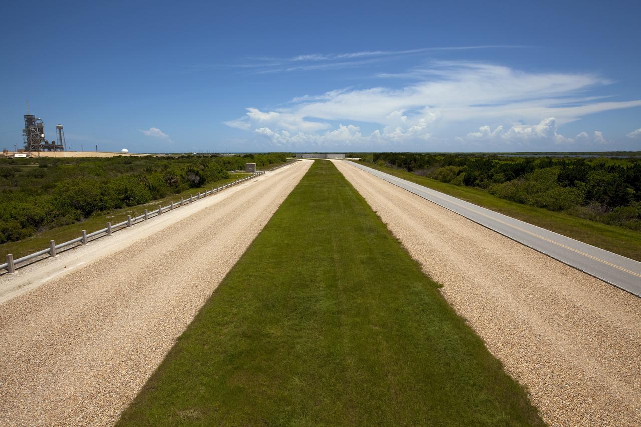 CAPE CANAVERAL, Fla. – The gravel crawlerway is seen as if from a crawler transporter approaching Launch Complex 39 pad A at the Kennedy Space Center in Florida. The crawlerways are 130 feet wide, about the size of an 8-lane freeway. The river rock paths have been used since 1966 to move launch vehicles from the Vehicle Assembly Building, or VAB, along the 3.4-mile path to pad A and 6.8 miles to pad B. The crawlerways were originally built to support transporting Apollo Saturn V rockets to the launch pads. The crawlerways were again used during the Space Shuttle Program moving the 4.5 million-pound shuttles mounted on an 8-million-pound mobile launcher platform atop a six-million-pound crawler transporter -- totaling an 18.5-million-pound vehicle lumbering along to the pad. The paths are specially constructed with four layers. The top is eight inches thick on curves and four inches on straightaway sections. Then there is a four-foot layer of graded, crushed stone. Beneath that is 2.5 feet of fill, followed by one foot of compact fill. Plans call for the crawlerways to be used in the future for transporting launch vehicles from the VAB to pads A and B. For more information, visit http://www.nasa.gov/transition Photo credit: NASA/Kim Shiflett