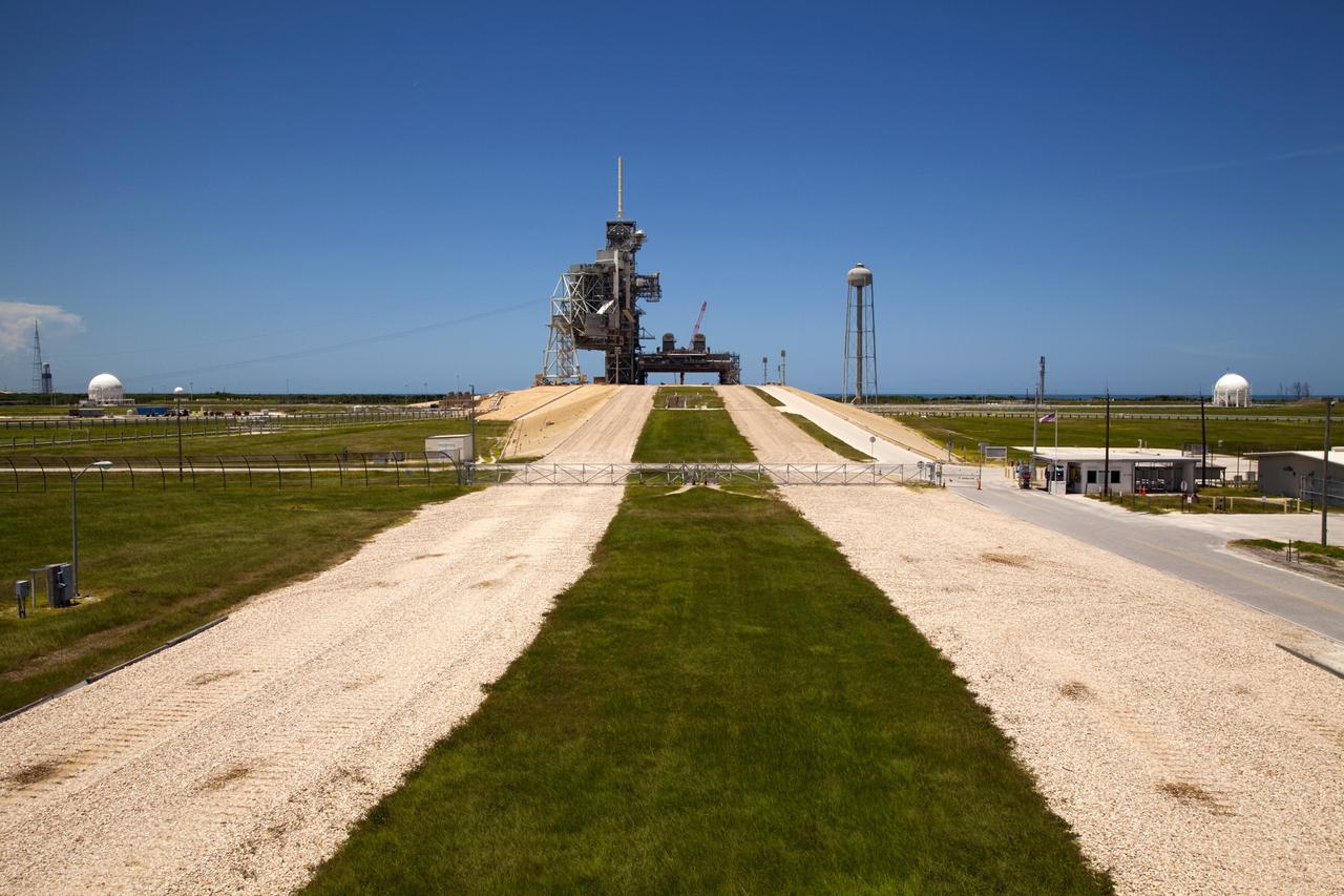 CAPE CANAVERAL, Fla. – The gravel crawlerway is seen as if from a crawler transporter making the approach to Launch Complex 39 pad A at the Kennedy Space Center in Florida. The crawlerways are 130 feet wide, about the size of an 8-lane freeway. The river rock paths have been used since 1966 to move launch vehicles from the Vehicle Assembly Building, or VAB, along the 3.4-mile path to pad A and 6.8 miles to pad B. The crawlerways were originally built to support transporting Apollo Saturn V rockets to the launch pads. The crawlerways were again used during the Space Shuttle Program moving the 4.5 million-pound shuttles mounted on an 8-million-pound mobile launcher platform atop a six-million-pound crawler transporter -- totaling an 18.5-million-pound vehicle lumbering along to the pad. The paths are specially constructed with four layers. The top is eight inches thick on curves and four inches on straightaway sections. Then there is a four-foot layer of graded, crushed stone. Beneath that is 2.5 feet of fill, followed by one foot of compact fill. Plans call for the crawlerways to be used in the future for transporting launch vehicles from the VAB to pads A and B. For more information, visit http://www.nasa.gov/transition Photo credit: NASA/Kim Shiflett