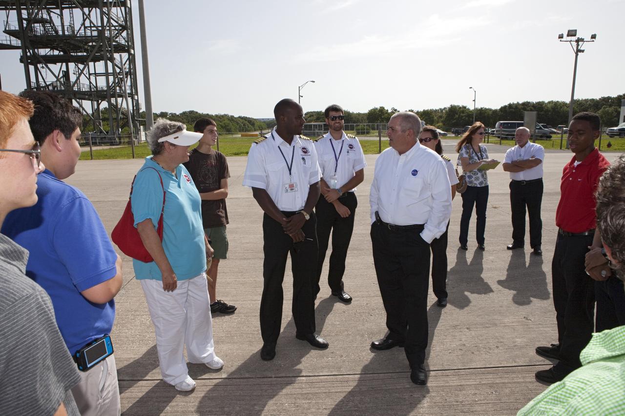 CAPE CANAVERAL, Fla. – At NASA Kennedy Space Center’s Shuttle Landing Facility, or SLF, in Florida, NASA Aviation Safety Officer Joe Torsani, at right, speaks with students and their flight instructors after they arrived in Cherokee Warrior and Cessna 172S lightweight aircraft from Florida Tech, or FIT, in Melbourne.     The middle and high school students are participating in FIT’s Av/Aero summer camp experience. They and their flight instructors toured the SLF midfield control tower, viewed F104 Starfighters and NASA Huey helicopters in the RLV Hangar, viewed the runway plaques marking wheels stop for each of the three space shuttles, and toured the Vehicle Assembly Building where space shuttle Atlantis currently is stored. Photo credit: NASA/Kim Shiflett