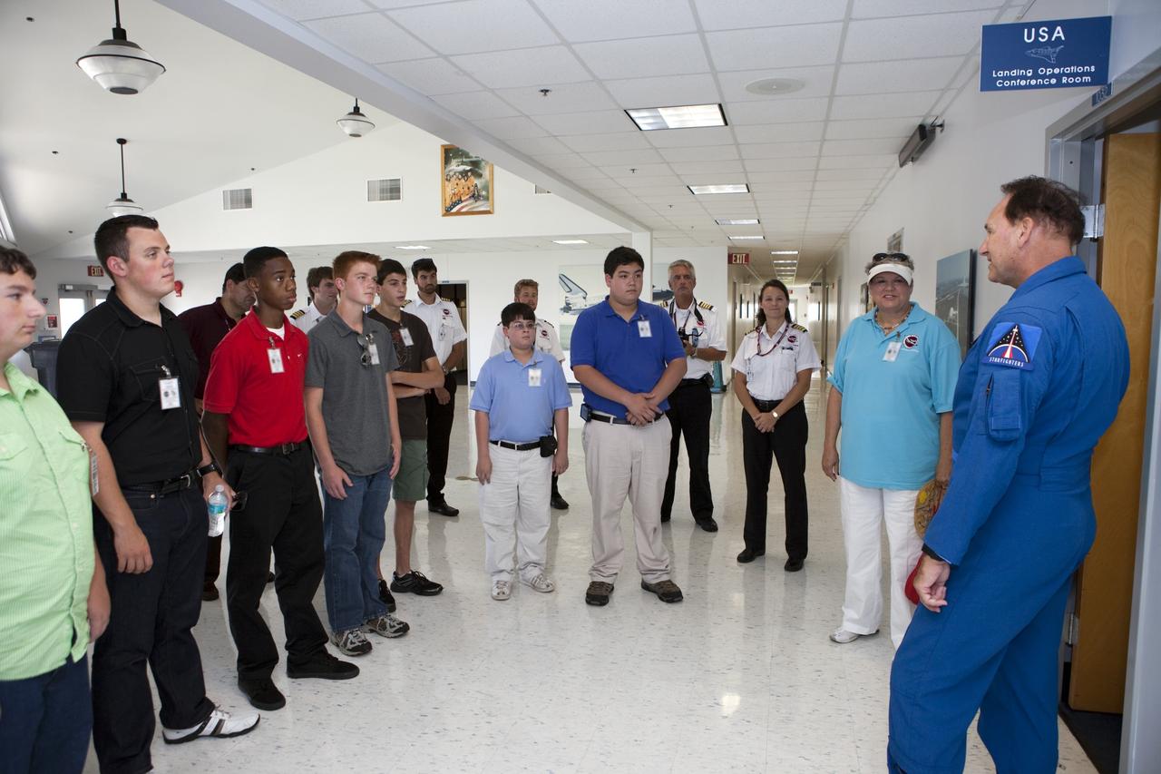 CAPE CANAVERAL, Fla. – In a support building near NASA Kennedy Space Center’s Shuttle Landing Facility, or SLF, in Florida, students and their flight instructors from Florida Tech, FIT, in Melbourne listen to F104 Starfighters Director Rick Svetkoff.    The middle and high school students are participating in FIT’s Av/Aero summer camp experience. They and their flight instructors toured the SLF midfield control tower, viewed F104 Starfighters and NASA Huey helicopters in the RLV Hangar, viewed the runway plaques marking wheels stop for each of the three space shuttles, and toured the Vehicle Assembly Building where space shuttle Atlantis currently is stored. Photo credit: NASA/Kim Shiflett