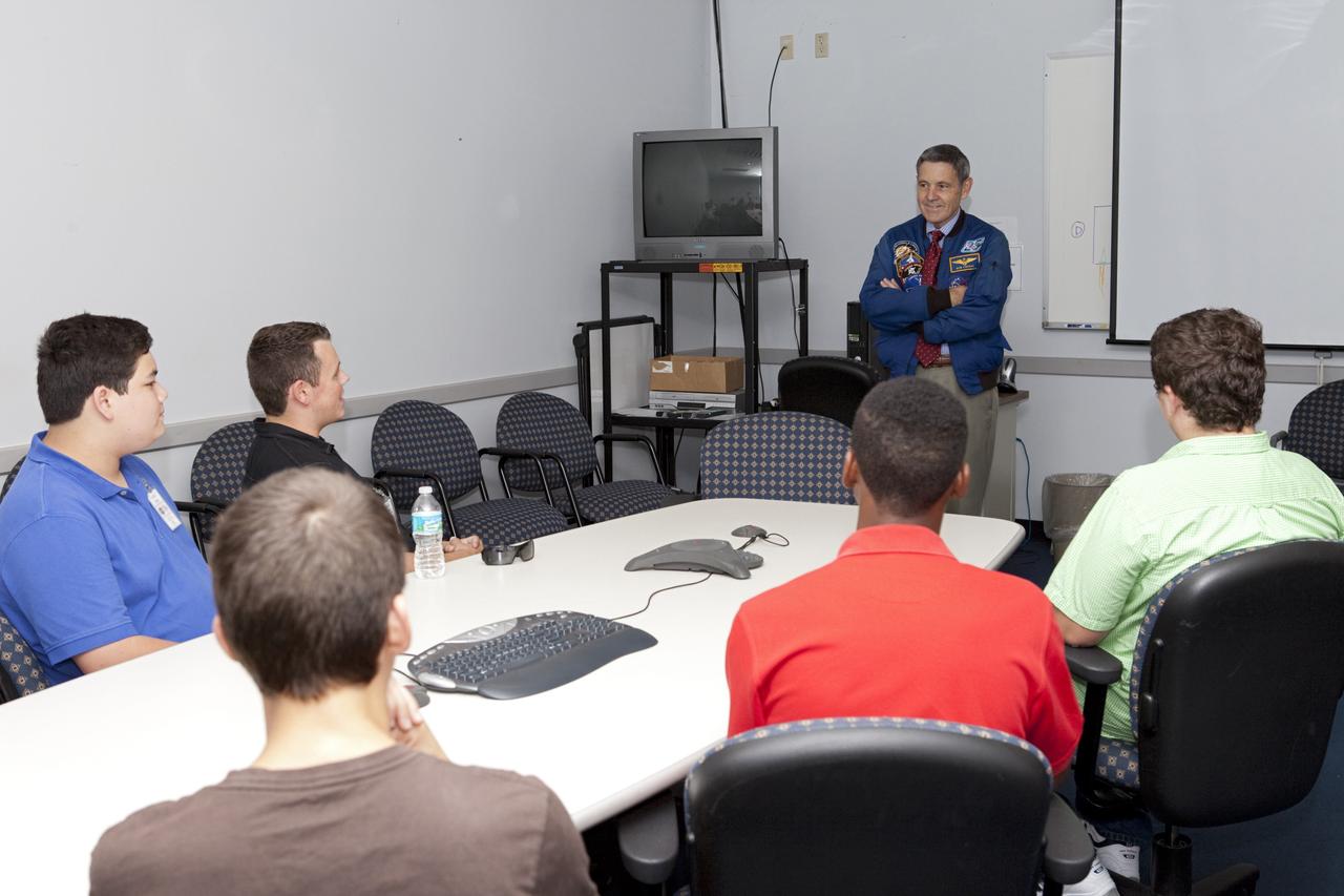 CAPE CANAVERAL, Fla. – In a support building near NASA Kennedy Space Center’s Shuttle Landing Facility, or SLF, in Florida, Center Director Bob Cabana speaks to students and their flight instructors from Florida Tech, or FIT, in Melbourne. The group arrived at the SLF in Cherokee Warrior and Cessna 172S lightweight aircraft..    The middle and high school students are participating in FIT’s Av/Aero summer camp experience. They and their flight instructors toured the SLF midfield control tower, viewed F104 Starfighters and NASA Huey helicopters in the RLV Hangar, viewed the runway plaques marking wheels stop for each of the three space shuttles, and toured the Vehicle Assembly Building where space shuttle Atlantis currently is stored. Photo credit: NASA/Kim Shiflett