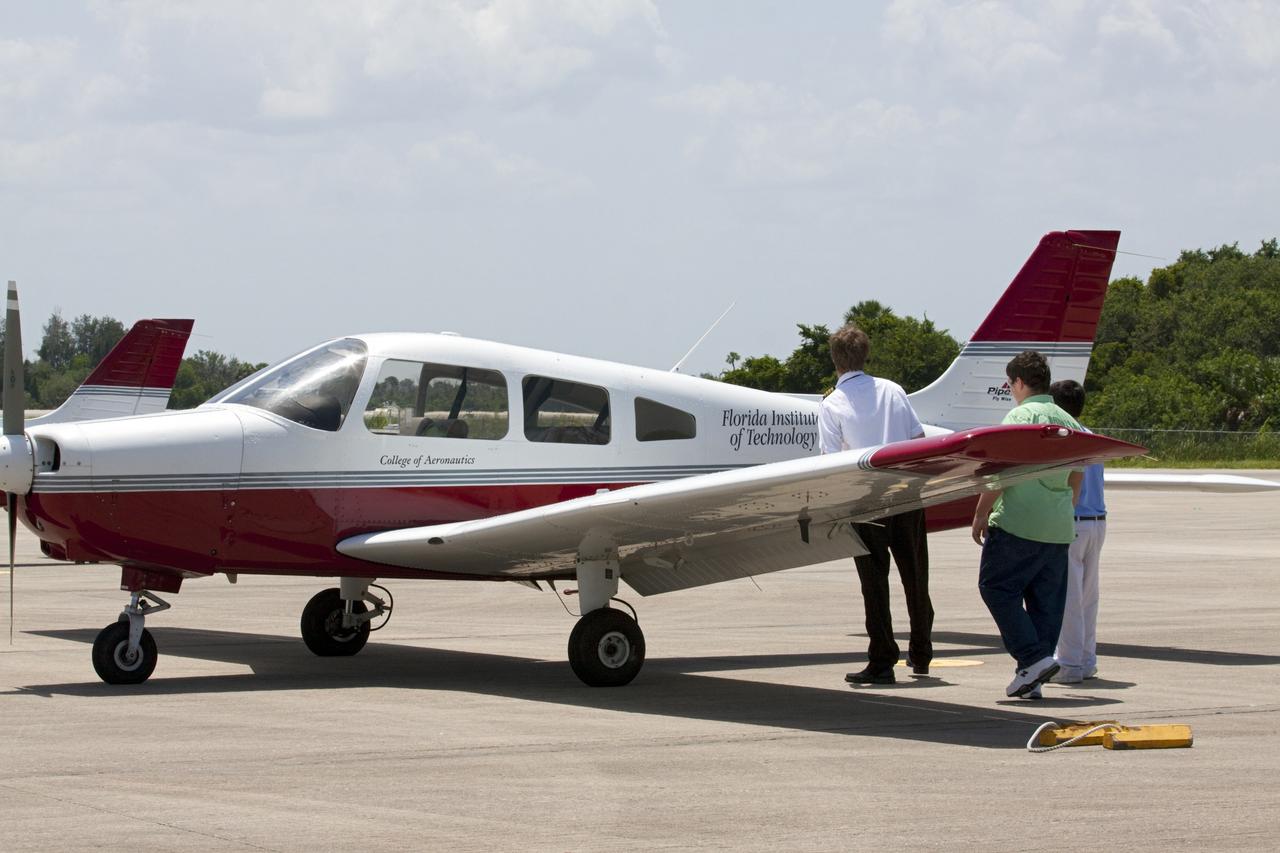 CAPE CANAVERAL, Fla. – At NASA Kennedy Space Center’s Shuttle Landing Facility, or SLF, in Florida, a flight instructor and his students inspect the lightweight aircraft they flew in earlier in the day from Florida Tech, or FIT, in Melbourne. Several instructors and their students arrived at the SLF in Cherokee Warrior and Cessna 172S lightweight aircraft.    The middle and high school students are participating in FIT’s Av/Aero summer camp experience. They and their flight instructors toured the SLF midfield control tower, viewed F104 Starfighters and NASA Huey helicopters in the RLV Hangar, viewed the runway plaques marking wheels stop for each of the three space shuttles, and toured the Vehicle Assembly Building where space shuttle Atlantis currently is stored. Photo credit: NASA/Kim Shiflett