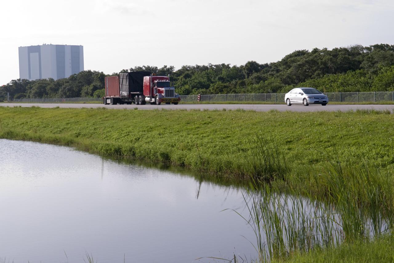 CAPE CANAVERAL, Fla. - A truck transporting NASA's Morpheus lander, a vertical test bed vehicle, heads towards the Shuttle Landing Facility, or SLF, at the Kennedy Space Center in Florida for unloading. Morpheus is designed to demonstrate new green propellant propulsion systems and autonomous landing and an Autonomous Landing and Hazard Avoidance Technology, or ALHAT, system. Checkout of the prototype lander has been ongoing at NASA’s Johnson Space Center in Houston in preparation for its first free flight. The SLF site will provide the lander with the kind of field necessary for realistic testing. Project Morpheus is one of 20 small projects comprising the Advanced Exploration Systems, or AES, program in NASA’s Human Exploration and Operations Mission Directorate. AES projects pioneer new approaches for rapidly developing prototype systems, demonstrating key capabilities and validating operational concepts for future human missions beyond Earth orbit. For more information on Project Morpheus, visit http://www.nasa.gov/centers/johnson/exploration/morpheus/index.html Photo credit: NASA/ Charisse Nahser