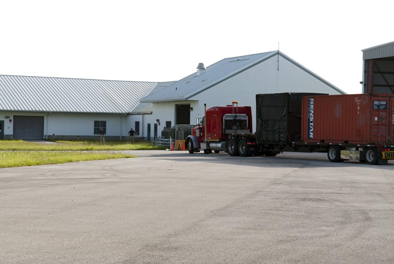 CAPE CANAVERAL, Fla. - A truck transporting NASA's Morpheus lander, a vertical test bed vehicle, arrives at a building at the Shuttle Landing Facility, or SLF, at the Kennedy Space Center in Florida for unloading. Morpheus is designed to demonstrate new green propellant propulsion systems and autonomous landing and an Autonomous Landing and Hazard Avoidance Technology, or ALHAT, system.      Checkout of the prototype lander has been ongoing at NASA’s Johnson Space Center in Houston in preparation for its first free flight. The SLF site will provide the lander with the kind of field necessary for realistic testing. Project Morpheus is one of 20 small projects comprising the Advanced Exploration Systems, or AES, program in NASA’s Human Exploration and Operations Mission Directorate. AES projects pioneer new approaches for rapidly developing prototype systems, demonstrating key capabilities and validating operational concepts for future human missions beyond Earth orbit. For more information on Project Morpheus, visit http://www.nasa.gov/centers/johnson/exploration/morpheus/index.html  Photo credit: NASA/ Charisse Nahser