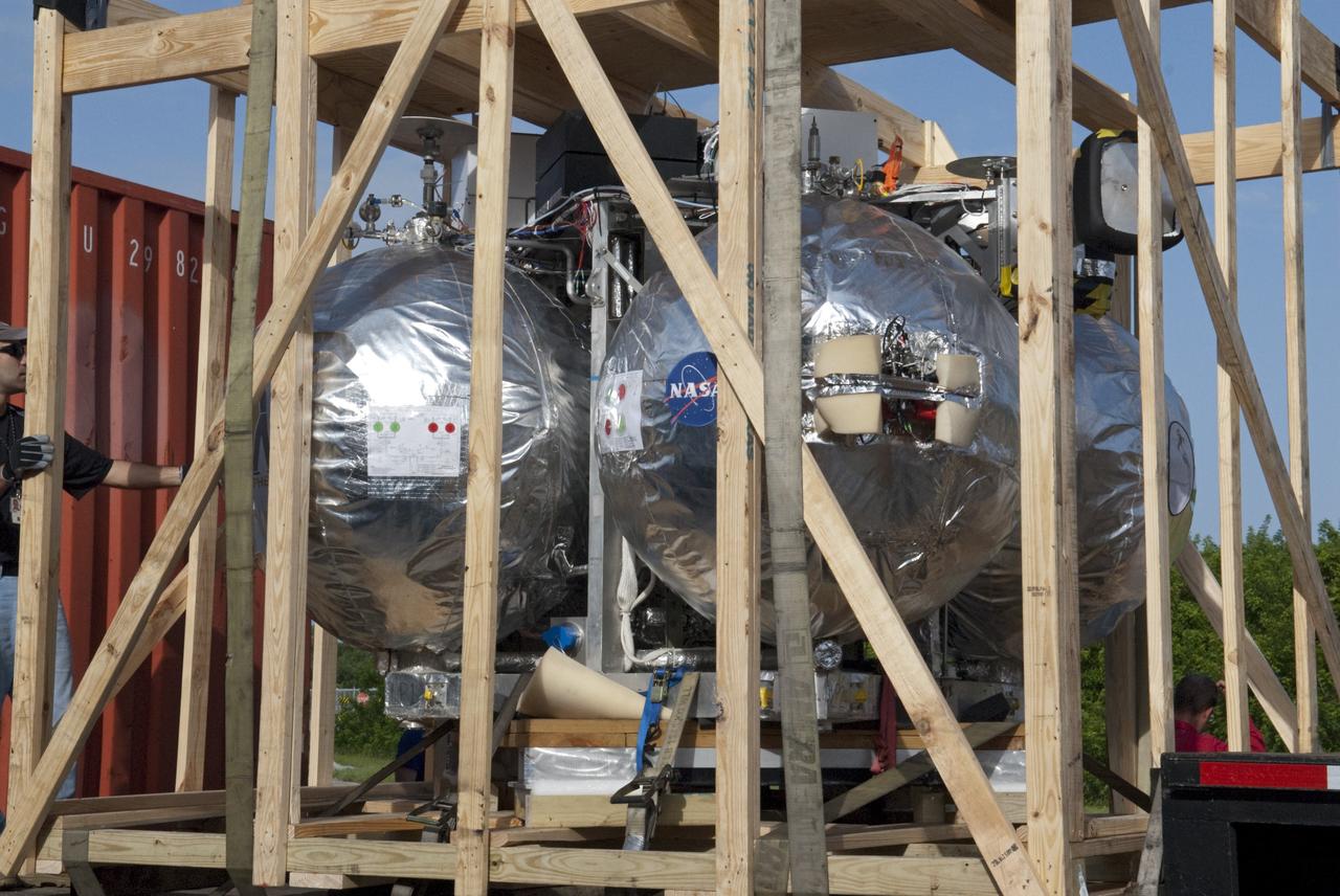 CAPE CANAVERAL, Fla. - NASA's Morpheus lander, a vertical test bed vehicle, is ready to be uncrated at the Kennedy Space Center in Florida. Morpheus is designed to demonstrate new green propellant propulsion systems and autonomous landing and an Autonomous Landing and Hazard Avoidance Technology, or ALHAT, system.      Checkout of the prototype lander has been ongoing at NASA’s Johnson Space Center in Houston in preparation for its first free flight. The SLF site will provide the lander with the kind of field necessary for realistic testing. Project Morpheus is one of 20 small projects comprising the Advanced Exploration Systems, or AES, program in NASA’s Human Exploration and Operations Mission Directorate. AES projects pioneer new approaches for rapidly developing prototype systems, demonstrating key capabilities and validating operational concepts for future human missions beyond Earth orbit. For more information on Project Morpheus, visit http://www.nasa.gov/centers/johnson/exploration/morpheus/index.html  Photo credit: NASA/ Charisse Nahser