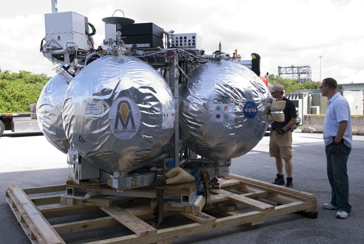 CAPE CANAVERAL, Fla. - NASA's Morpheus lander, a vertical test bed vehicle, is unloaded at the Kennedy Space Center in Florida. Morpheus is designed to demonstrate new green propellant propulsion systems and autonomous landing and an Autonomous Landing and Hazard Avoidance Technology, or ALHAT, system. Checkout of the prototype lander has been ongoing at NASA’s Johnson Space Center in Houston in preparation for its first free flight. The SLF site will provide the lander with the kind of field necessary for realistic testing. Project Morpheus is one of 20 small projects comprising the Advanced Exploration Systems, or AES, program in NASA’s Human Exploration and Operations Mission Directorate. AES projects pioneer new approaches for rapidly developing prototype systems, demonstrating key capabilities and validating operational concepts for future human missions beyond Earth orbit. For more information on Project Morpheus, visit http://www.nasa.gov/centers/johnson/exploration/morpheus/index.html Photo credit: NASA/ Charisse Nahser