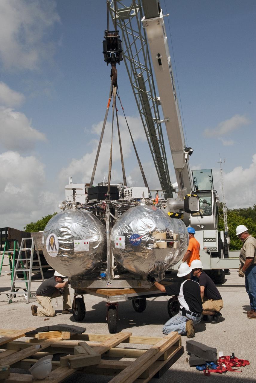 CAPE CANAVERAL, Fla. - A crane supports unloading of NASA's Morpheus lander, a vertical test bed vehicle, at the Kennedy Space Center in Florida. Morpheus is designed to demonstrate new green propellant propulsion systems and autonomous landing and an Autonomous Landing and Hazard Avoidance Technology, or ALHAT, system.      Checkout of the prototype lander has been ongoing at NASA’s Johnson Space Center in Houston in preparation for its first free flight. The SLF site will provide the lander with the kind of field necessary for realistic testing. Project Morpheus is one of 20 small projects comprising the Advanced Exploration Systems, or AES, program in NASA’s Human Exploration and Operations Mission Directorate. AES projects pioneer new approaches for rapidly developing prototype systems, demonstrating key capabilities and validating operational concepts for future human missions beyond Earth orbit. For more information on Project Morpheus, visit http://www.nasa.gov/centers/johnson/exploration/morpheus/index.html  Photo credit: NASA/ Charisse Nahser