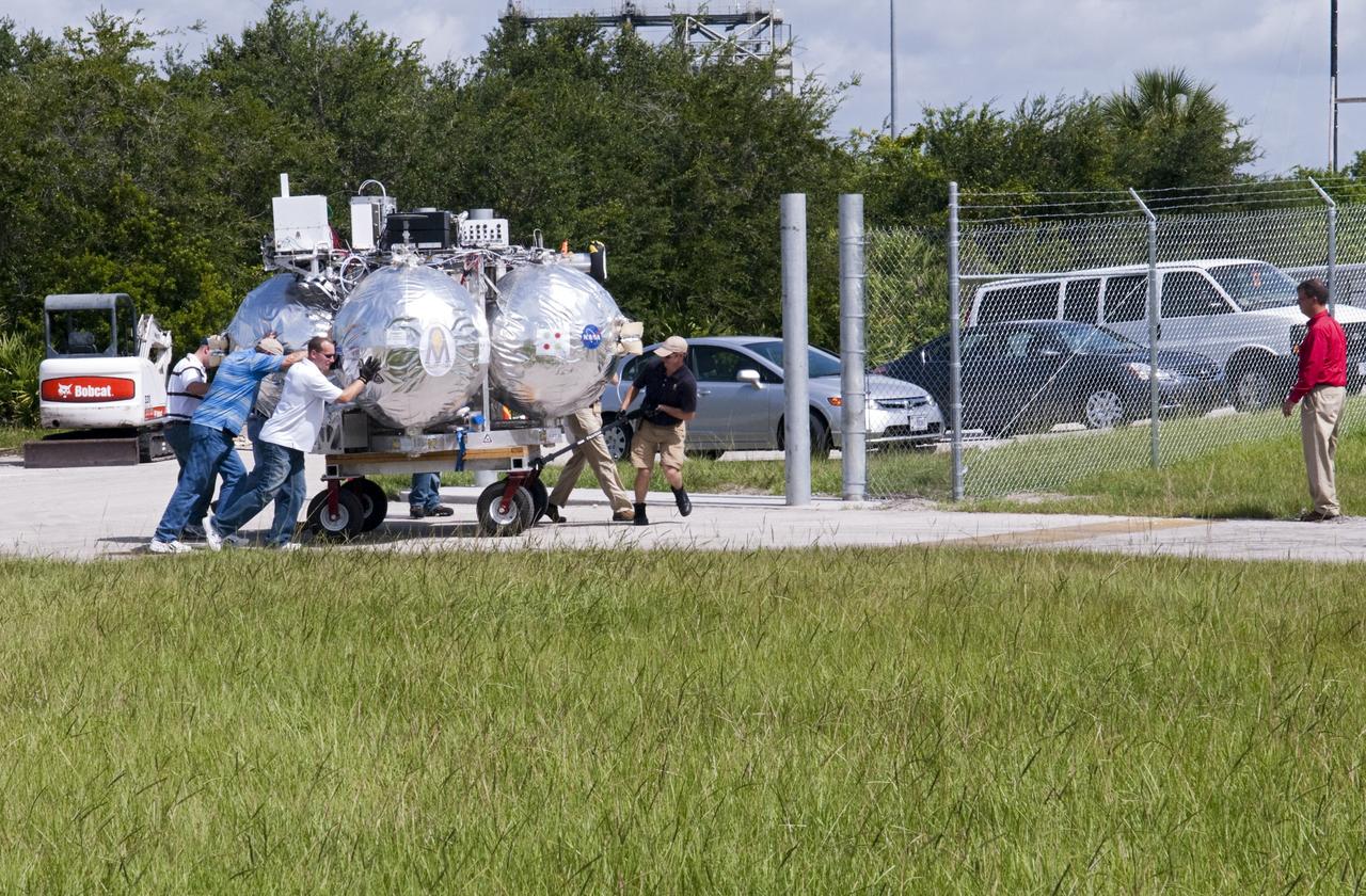 CAPE CANAVERAL, Fla. - NASA's Morpheus lander, a vertical test bed vehicle, is moved into a building at the Shuttle Landing Facility, or SLF, at the Kennedy Space Center in Florida. Morpheus is designed to demonstrate new green propellant propulsion systems and autonomous landing and an Autonomous Landing and Hazard Avoidance Technology, or ALHAT, system.      Checkout of the prototype lander has been ongoing at NASA’s Johnson Space Center in Houston in preparation for its first free flight. The SLF site will provide the lander with the kind of field necessary for realistic testing. Project Morpheus is one of 20 small projects comprising the Advanced Exploration Systems, or AES, program in NASA’s Human Exploration and Operations Mission Directorate. AES projects pioneer new approaches for rapidly developing prototype systems, demonstrating key capabilities and validating operational concepts for future human missions beyond Earth orbit. For more information on Project Morpheus, visit http://www.nasa.gov/centers/johnson/exploration/morpheus/index.html  Photo credit: NASA/ Charisse Nahser