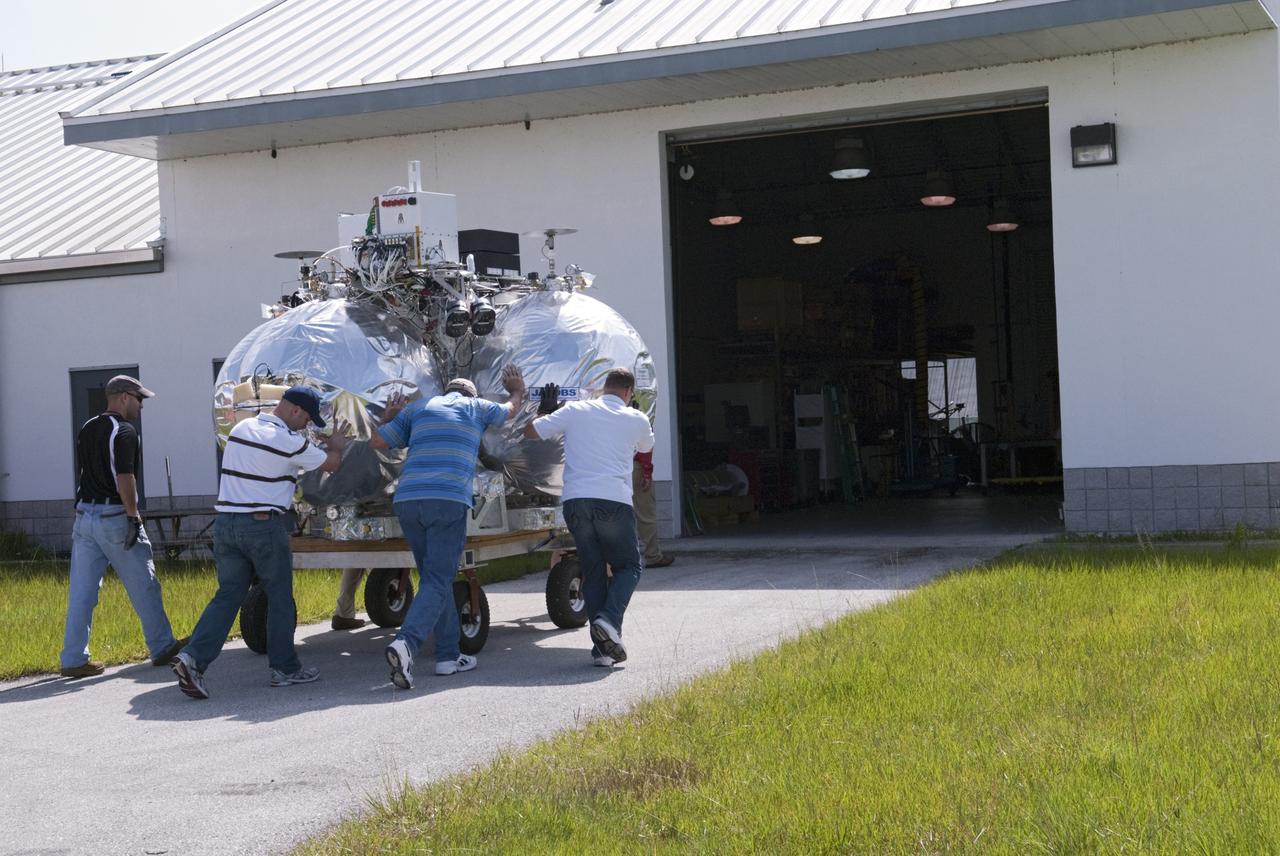 CAPE CANAVERAL, Fla. - NASA's Morpheus lander, a vertical test bed vehicle, is moved into a building at the Shuttle Landing Facility, or SLF, at the Kennedy Space Center in Florida. Morpheus is designed to demonstrate new green propellant propulsion systems and autonomous landing and an Autonomous Landing and Hazard Avoidance Technology, or ALHAT, system. Checkout of the prototype lander has been ongoing at NASA’s Johnson Space Center in Houston in preparation for its first free flight. The SLF site will provide the lander with the kind of field necessary for realistic testing. Project Morpheus is one of 20 small projects comprising the Advanced Exploration Systems, or AES, program in NASA’s Human Exploration and Operations Mission Directorate. AES projects pioneer new approaches for rapidly developing prototype systems, demonstrating key capabilities and validating operational concepts for future human missions beyond Earth orbit. For more information on Project Morpheus, visit http://www.nasa.gov/centers/johnson/exploration/morpheus/index.html Photo credit: NASA/ Charisse Nahser