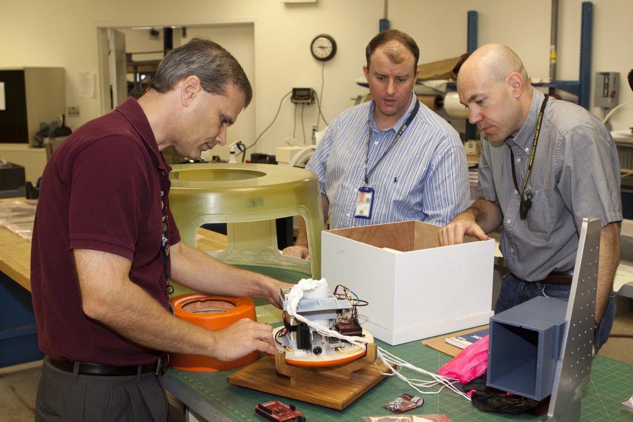 CAPE CANAVERAL, Fla. – Rocket University participants inspect a capsule that is being prepared for a high-altitude balloon flight. The test flight was used to evaluate the stability of an instrumented capsule as it fell to Earth before its parachute opened. Rocket University is a program of courses, workshops, labs and projects offered to engineering and research pros of all stripes to keep their skills fresh and broaden their experiences. Photo credit: NASA/Jim Grossmann