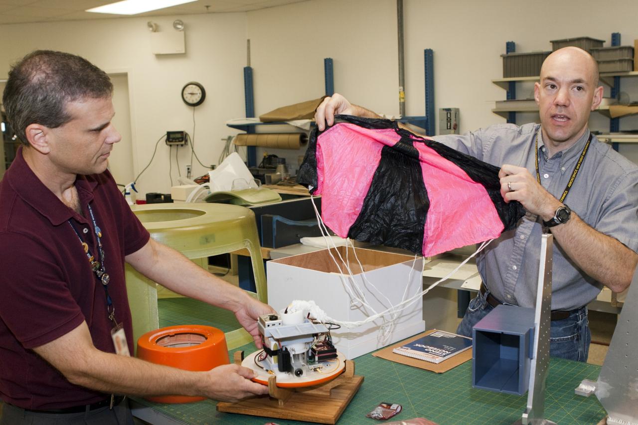 CAPE CANAVERAL, Fla. – Paul Paulick, left, and Ron Sterick, both participants in the Rocket University program, inspect a capsule and parachute that are being prepared for a high-altitude balloon flight. The test flight was used to evaluate the stability of an instrumented capsule as it fell to Earth before its parachute opened. Rocket University is a program of courses, workshops, labs and projects offered to engineering and research pros of all stripes to keep their skills fresh and broaden their experiences. Photo credit: NASA/Jim Grossmann