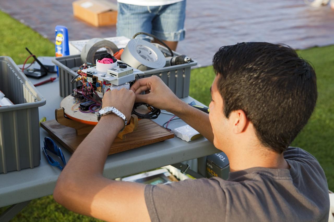 CAPE CANAVERAL, Fla. – Alejandro Azocar, a Rocket University participant, prepares an instrument package to launch on a high-altitude balloon flight. The test flight was used to evaluate the stability of an instrumented capsule as it fell to Earth before its parachute opened. Rocket University is a program of courses, workshops, labs and projects offered to engineering and research pros of all stripes to keep their skills fresh and broaden their experiences. Photo credit: NASA/Jim Grossmann
