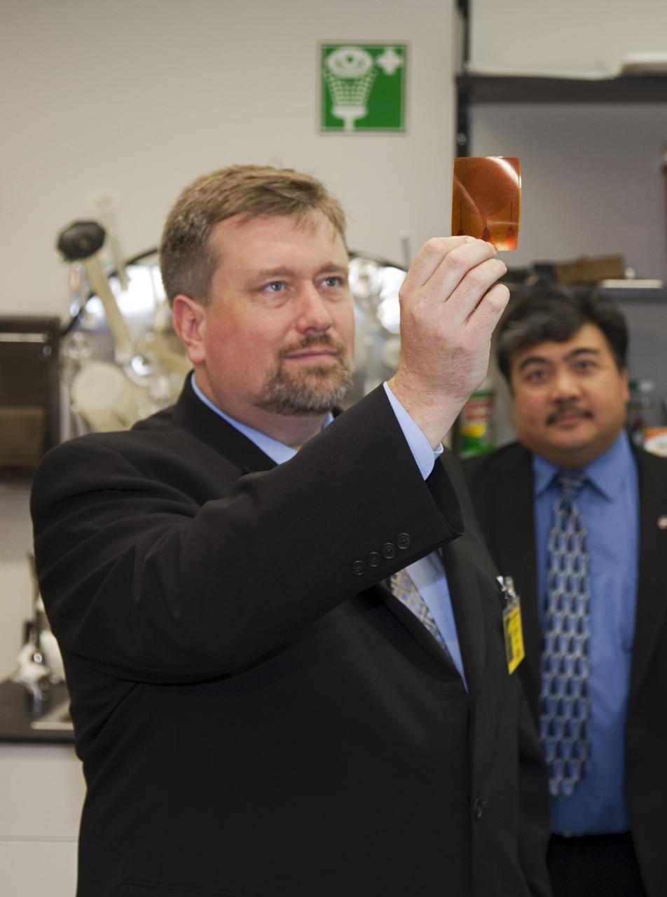 CAPE CANAVERAl, Fla. - Dr. Mason Peck, left, NASA's chief Technologist, examines an innovative conductive material during a tour of the Space Life Sciences Laboratory at Kennedy. Peck toured the lab facility during a visit to the space center. Photo credit: NASA/Frankie Martin