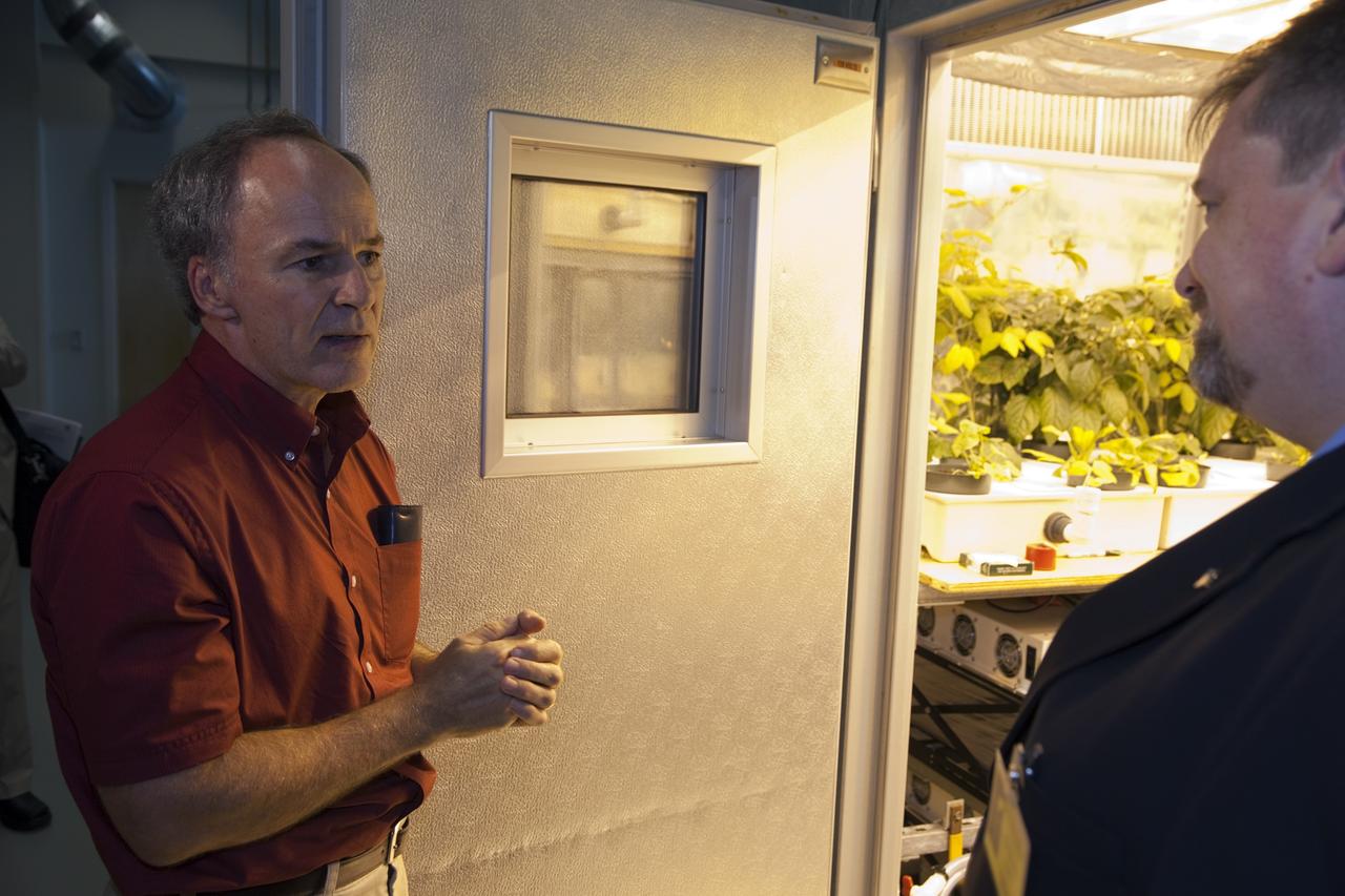CAPE CANAVERAl, Fla. - Dr. Ray Wheeler, left, explains a plant experiment to Dr. Mason Peck, NASA's chief Technologist, during a tour of the Space Life Sciences Laboratory at Kennedy. Peck toured the lab facility during a visit to the space center. Photo credit: NASA/Frankie Martin