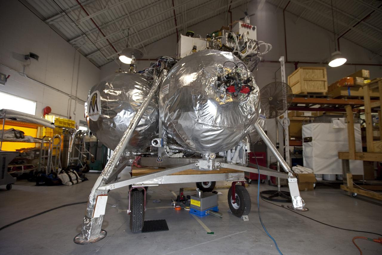 CAPE CANAVERAL, Fla. - NASA's Morpheus lander, a vertical test bed vehicle, is being checked out in a building at the Shuttle Landing Facility, or SLF, at the Kennedy Space Center in Florida. Morpheus is designed to demonstrate new green propellant propulsion systems and autonomous landing and an Autonomous Landing and Hazard Avoidance Technology, or ALHAT, system. Checkout of the prototype lander has been ongoing at NASA’s Johnson Space Center in Houston in preparation for its first free flight. The SLF site will provide the lander with the kind of field necessary for realistic testing. Project Morpheus is one of 20 small projects comprising the Advanced Exploration Systems, or AES, program in NASA’s Human Exploration and Operations Mission Directorate. AES projects pioneer new approaches for rapidly developing prototype systems, demonstrating key capabilities and validating operational concepts for future human missions beyond Earth orbit. For more information on Project Morpheus, visit http://www.nasa.gov/centers/johnson/exploration/morpheus/index.html Photo credit: NASA/Dimitri Gerondidakis