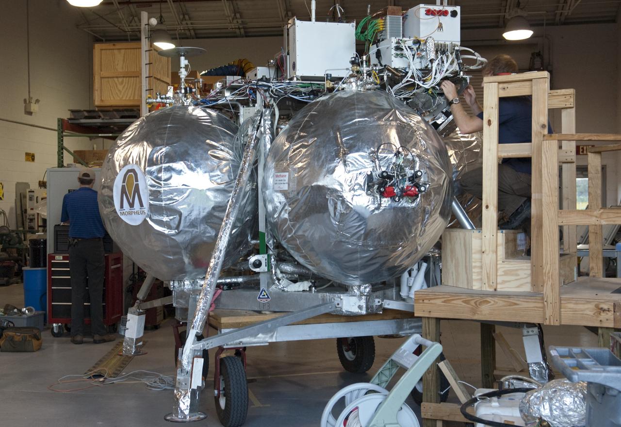 CAPE CANAVERAL, Fla. - NASA's Morpheus lander, a vertical test bed vehicle, is being checked out in a building at the Shuttle Landing Facility, or SLF, at the Kennedy Space Center in Florida. Morpheus is designed to demonstrate new green propellant propulsion systems and autonomous landing and an Autonomous Landing and Hazard Avoidance Technology, or ALHAT, system. Checkout of the prototype lander has been ongoing at NASA’s Johnson Space Center in Houston in preparation for its first free flight. The SLF site will provide the lander with the kind of field necessary for realistic testing. Project Morpheus is one of 20 small projects comprising the Advanced Exploration Systems, or AES, program in NASA’s Human Exploration and Operations Mission Directorate. AES projects pioneer new approaches for rapidly developing prototype systems, demonstrating key capabilities and validating operational concepts for future human missions beyond Earth orbit. For more information on Project Morpheus, visit http://www.nasa.gov/centers/johnson/exploration/morpheus/index.html Photo credit: NASA/Dimitri Gerondidakis