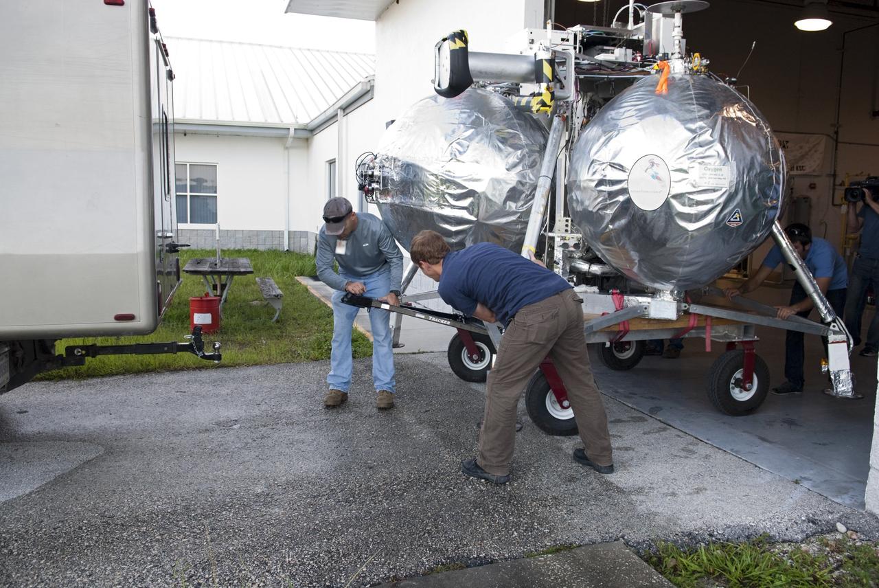 CAPE CANAVERAL, Fla. - NASA's Morpheus lander, a vertical test bed vehicle, is being moved out of its checkout building for a short trip to a launch position at the Shuttle Landing Facility, or SLF, at the Kennedy Space Center in Florida. Morpheus is designed to demonstrate new green propellant propulsion systems and autonomous landing and an Autonomous Landing and Hazard Avoidance Technology, or ALHAT, system. Checkout of the prototype lander has been ongoing at NASA’s Johnson Space Center in Houston in preparation for its first free flight. The SLF site will provide the lander with the kind of field necessary for realistic testing. Project Morpheus is one of 20 small projects comprising the Advanced Exploration Systems, or AES, program in NASA’s Human Exploration and Operations Mission Directorate. AES projects pioneer new approaches for rapidly developing prototype systems, demonstrating key capabilities and validating operational concepts for future human missions beyond Earth orbit. For more information on Project Morpheus, visit http://www.nasa.gov/centers/johnson/exploration/morpheus/index.html Photo credit: NASA/Dimitri Gerondidakis