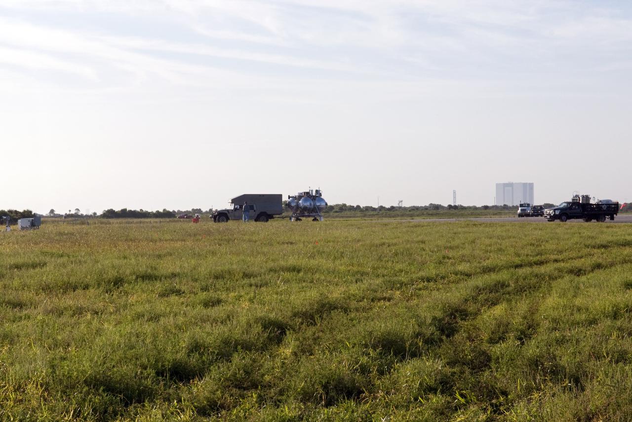 CAPE CANAVERAL, Fla. - NASA's Morpheus lander, a vertical test bed vehicle, is being transported along the Shuttle Landing Facility, or SLF, at the Kennedy Space Center in Florida for a short trip to a launch position along the runway. Morpheus is designed to demonstrate new green propellant propulsion systems and autonomous landing and an Autonomous Landing and Hazard Avoidance Technology, or ALHAT, system. Checkout of the prototype lander has been ongoing at NASA’s Johnson Space Center in Houston in preparation for its first free flight. The SLF site will provide the lander with the kind of field necessary for realistic testing. Project Morpheus is one of 20 small projects comprising the Advanced Exploration Systems, or AES, program in NASA’s Human Exploration and Operations Mission Directorate. AES projects pioneer new approaches for rapidly developing prototype systems, demonstrating key capabilities and validating operational concepts for future human missions beyond Earth orbit. For more information on Project Morpheus, visit http://www.nasa.gov/centers/johnson/exploration/morpheus/index.html Photo credit: NASA/Dimitri Gerondidakis