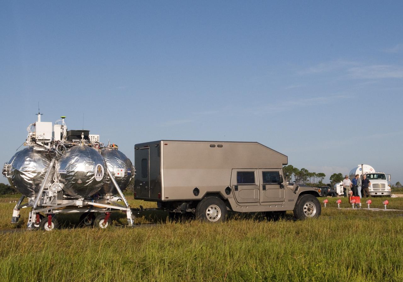 CAPE CANAVERAL, Fla. - NASA's Morpheus lander, a vertical test bed vehicle, is being transported along the Shuttle Landing Facility, or SLF, at the Kennedy Space Center in Florida for a short trip to a launch position along the runway. Morpheus is designed to demonstrate new green propellant propulsion systems and autonomous landing and an Autonomous Landing and Hazard Avoidance Technology, or ALHAT, system. Checkout of the prototype lander has been ongoing at NASA’s Johnson Space Center in Houston in preparation for its first free flight. The SLF site will provide the lander with the kind of field necessary for realistic testing. Project Morpheus is one of 20 small projects comprising the Advanced Exploration Systems, or AES, program in NASA’s Human Exploration and Operations Mission Directorate. AES projects pioneer new approaches for rapidly developing prototype systems, demonstrating key capabilities and validating operational concepts for future human missions beyond Earth orbit. For more information on Project Morpheus, visit http://www.nasa.gov/centers/johnson/exploration/morpheus/index.html Photo credit: NASA/Dimitri Gerondidakis