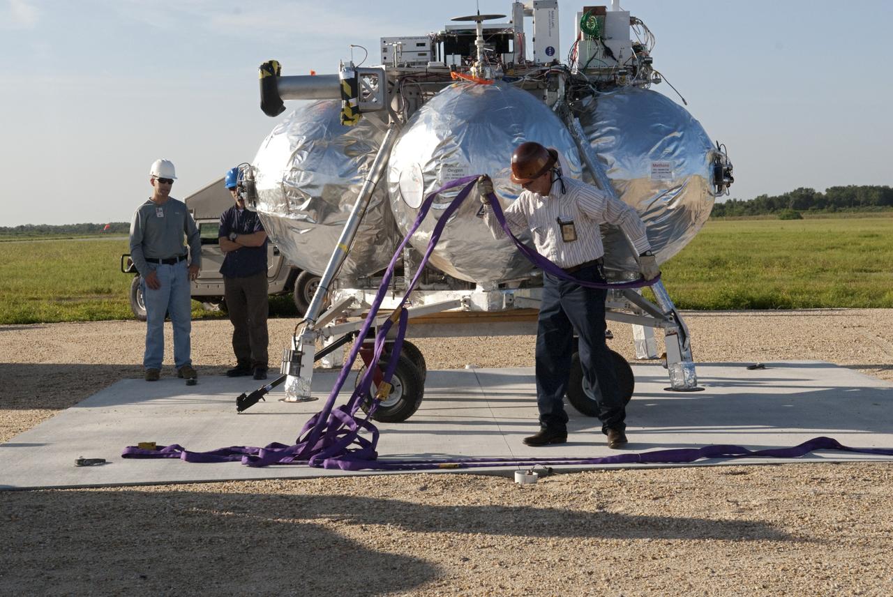 CAPE CANAVERAL, Fla. - NASA's Morpheus lander, a vertical test bed vehicle, is being set up at its launch position along the runway at the Shuttle Landing Facility, or SLF, at the Kennedy Space Center in Florida. Morpheus is designed to demonstrate new green propellant propulsion systems and autonomous landing and an Autonomous Landing and Hazard Avoidance Technology, or ALHAT, system. Checkout of the prototype lander has been ongoing at NASA’s Johnson Space Center in Houston in preparation for its first free flight. The SLF site will provide the lander with the kind of field necessary for realistic testing. Project Morpheus is one of 20 small projects comprising the Advanced Exploration Systems, or AES, program in NASA’s Human Exploration and Operations Mission Directorate. AES projects pioneer new approaches for rapidly developing prototype systems, demonstrating key capabilities and validating operational concepts for future human missions beyond Earth orbit. For more information on Project Morpheus, visit http://www.nasa.gov/centers/johnson/exploration/morpheus/index.html Photo credit: NASA/Dimitri Gerondidakis