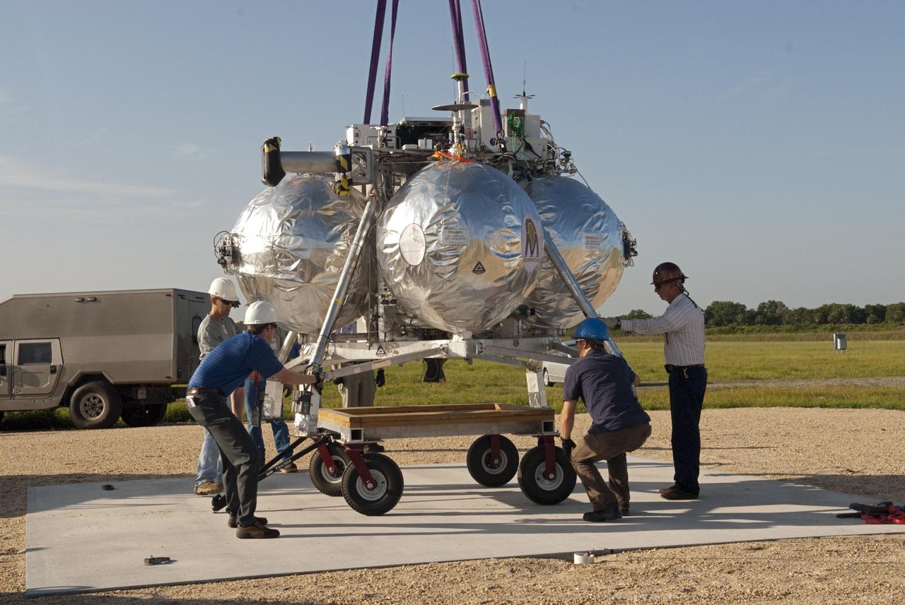 CAPE CANAVERAL, Fla. - Technicians set up NASA's Morpheus lander, a vertical test bed vehicle, at its launch position along the runway at the Shuttle Landing Facility, or SLF, at the Kennedy Space Center in Florida. Morpheus is designed to demonstrate new green propellant propulsion systems and autonomous landing and an Autonomous Landing and Hazard Avoidance Technology, or ALHAT, system. Checkout of the prototype lander has been ongoing at NASA’s Johnson Space Center in Houston in preparation for its first free flight. The SLF site will provide the lander with the kind of field necessary for realistic testing. Project Morpheus is one of 20 small projects comprising the Advanced Exploration Systems, or AES, program in NASA’s Human Exploration and Operations Mission Directorate. AES projects pioneer new approaches for rapidly developing prototype systems, demonstrating key capabilities and validating operational concepts for future human missions beyond Earth orbit. For more information on Project Morpheus, visit http://www.nasa.gov/centers/johnson/exploration/morpheus/index.html Photo credit: NASA/Dimitri Gerondidakis