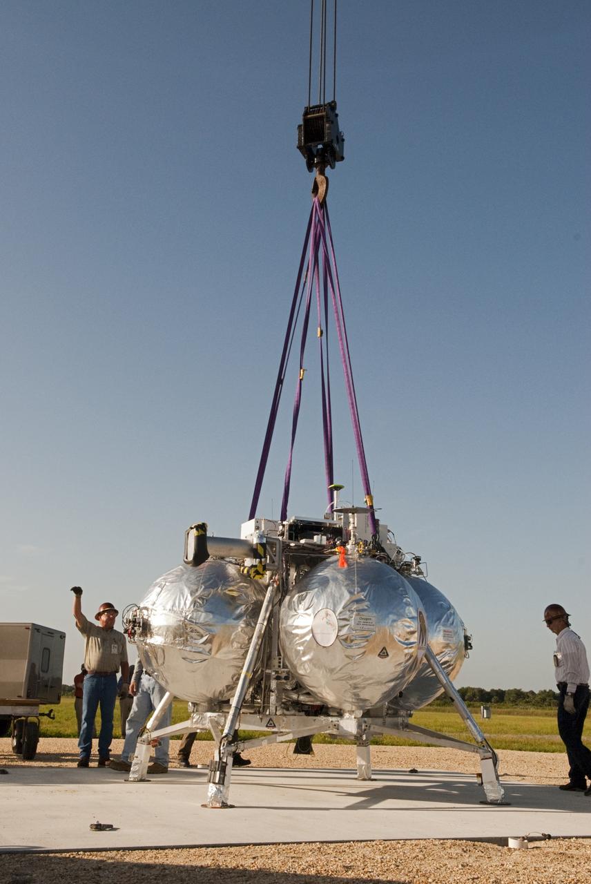 CAPE CANAVERAL, Fla. - A crane is being used to set up NASA's Morpheus lander, a vertical test bed vehicle, at its launch position along the runway at the Shuttle Landing Facility, or SLF, at the Kennedy Space Center in Florida. Morpheus is designed to demonstrate new green propellant propulsion systems and autonomous landing and an Autonomous Landing and Hazard Avoidance Technology, or ALHAT, system. Checkout of the prototype lander has been ongoing at NASA’s Johnson Space Center in Houston in preparation for its first free flight. The SLF site will provide the lander with the kind of field necessary for realistic testing. Project Morpheus is one of 20 small projects comprising the Advanced Exploration Systems, or AES, program in NASA’s Human Exploration and Operations Mission Directorate. AES projects pioneer new approaches for rapidly developing prototype systems, demonstrating key capabilities and validating operational concepts for future human missions beyond Earth orbit. For more information on Project Morpheus, visit http://www.nasa.gov/centers/johnson/exploration/morpheus/index.html Photo credit: NASA/Dimitri Gerondidakis