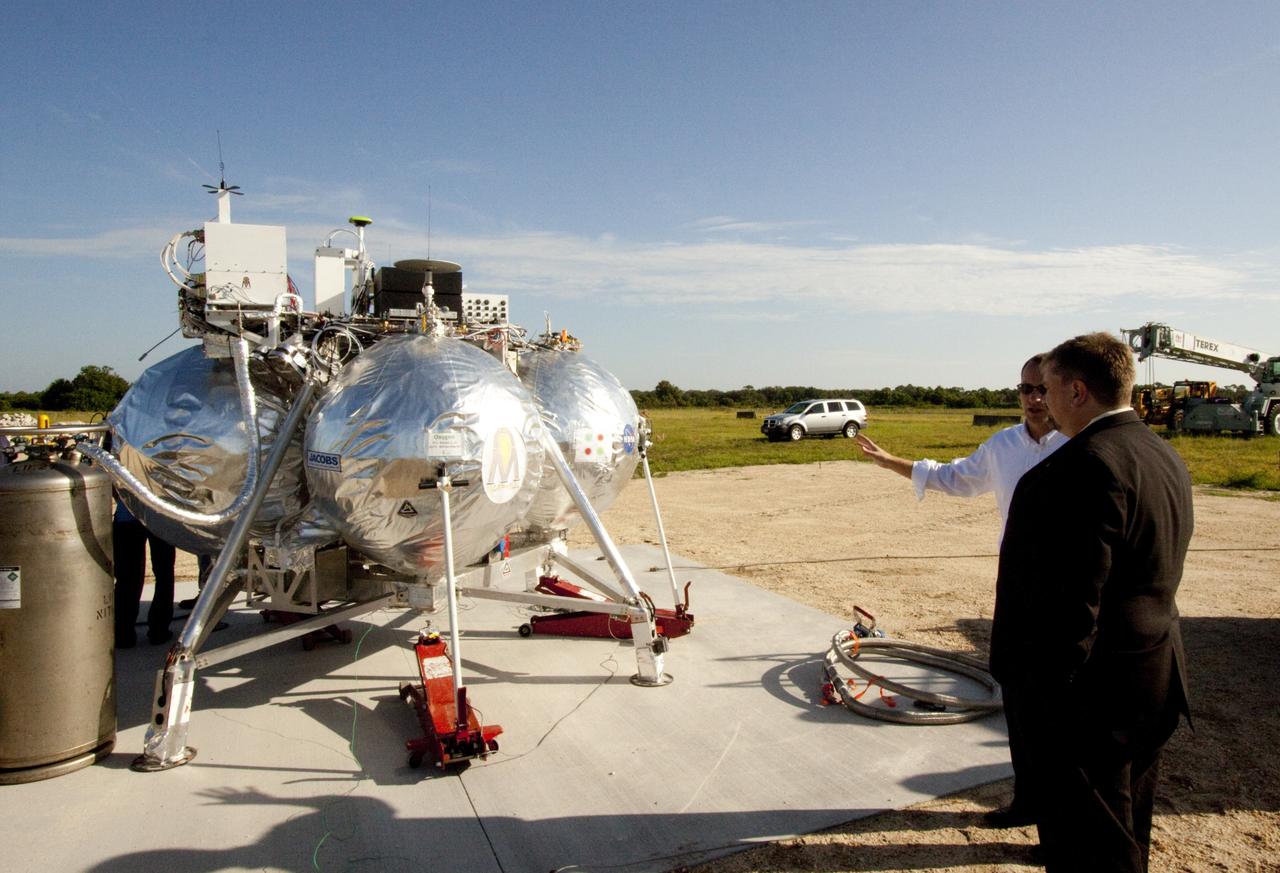 CAPE CANAVERAL, Fla. – Dr. Mason Peck, NASA's chief technologist, examines the Morpheus lander that will soon begin flight and landing tests at the Shuttle Landing Facility at NASA's Kennedy Space Center in Florida. Photo credit: NASA/Jim Grossman