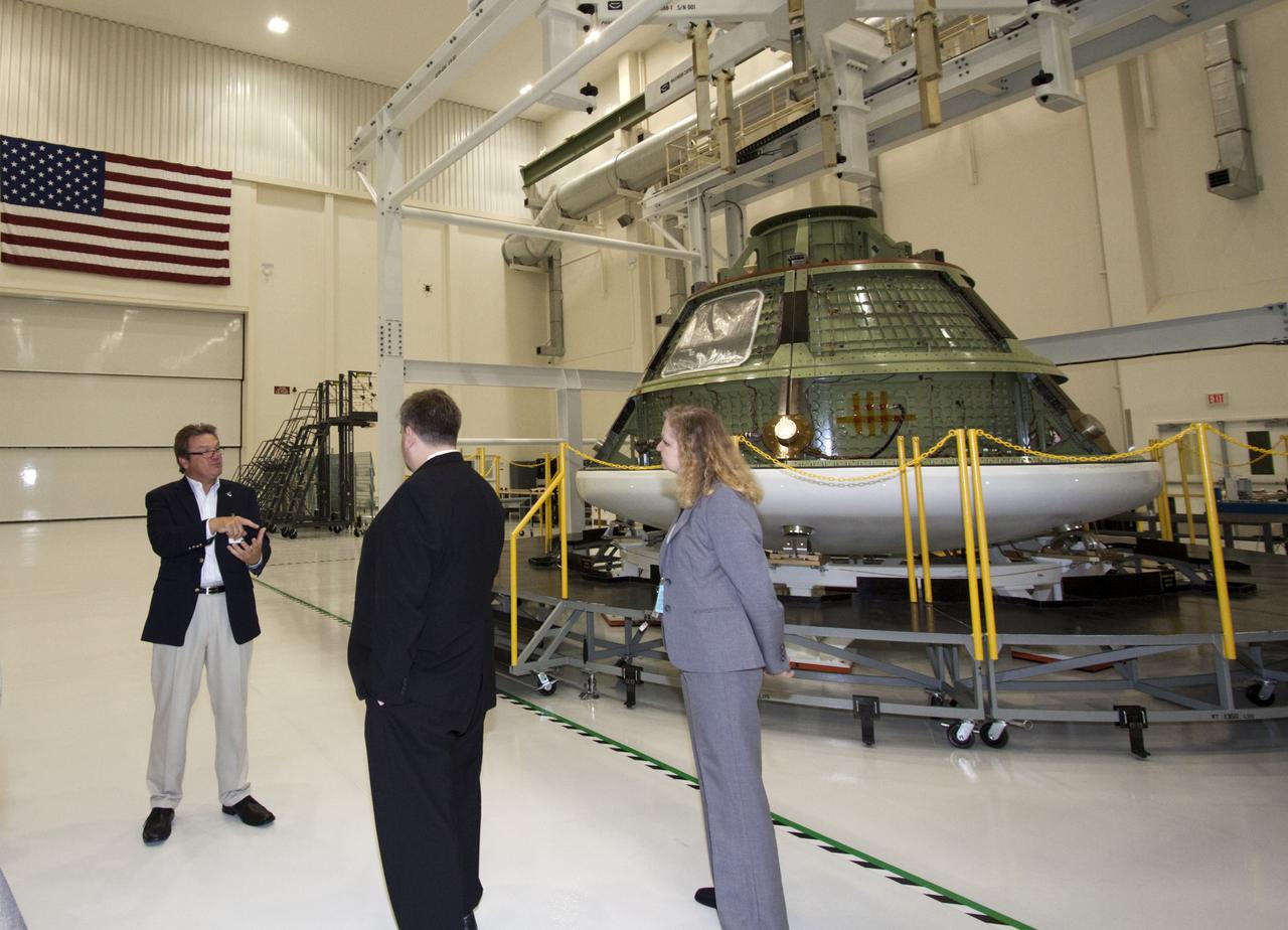 CAPE CANAVERAL, Fla. – Dr. Mason Peck, center, NASA's chief technologist, listens to details about the processing of the agency's first flight test Orion spacecraft by Lockheed Martin inside the Operations and Checkout Building's high bay at Kennedy Space Center in Florida. Lockheed Martin's Julian Schneider, left, led the presentation.  Photo credit: NASA/Jim Grossmann