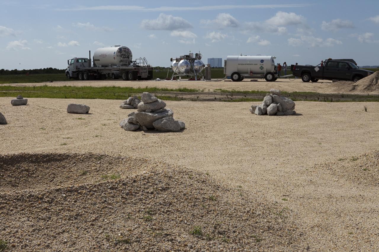 CAPE CANAVERAL, Fla. - At the north end of the Shuttle Landing Facility, or SLF, at the Kennedy Space Center in Florida, NASA's Morpheus lander, a vertical test bed vehicle, is being prepared for further assessment. A rock and crater-filled planetary scape, seen in the foreground, has been built so engineers can test the Autonomous Landing and Hazard Avoidance Technology, or ALHAT, system on the Project Morpheus lander. Checkout of the prototype lander has been ongoing at NASA’s Johnson Space Center in Houston in preparation for its first free flight. The SLF site will provide the lander with the kind of field necessary for realistic testing. Project Morpheus is one of 20 small projects comprising the Advanced Exploration Systems, or AES, program in NASA’s Human Exploration and Operations Mission Directorate. AES projects pioneer new approaches for rapidly developing prototype systems, demonstrating key capabilities and validating operational concepts for future human missions beyond Earth orbit. For more information on Project Morpheus, visit http://www.nasa.gov/centers/johnson/exploration/morpheus/index.html Photo credit: NASA/Kim Shiflett