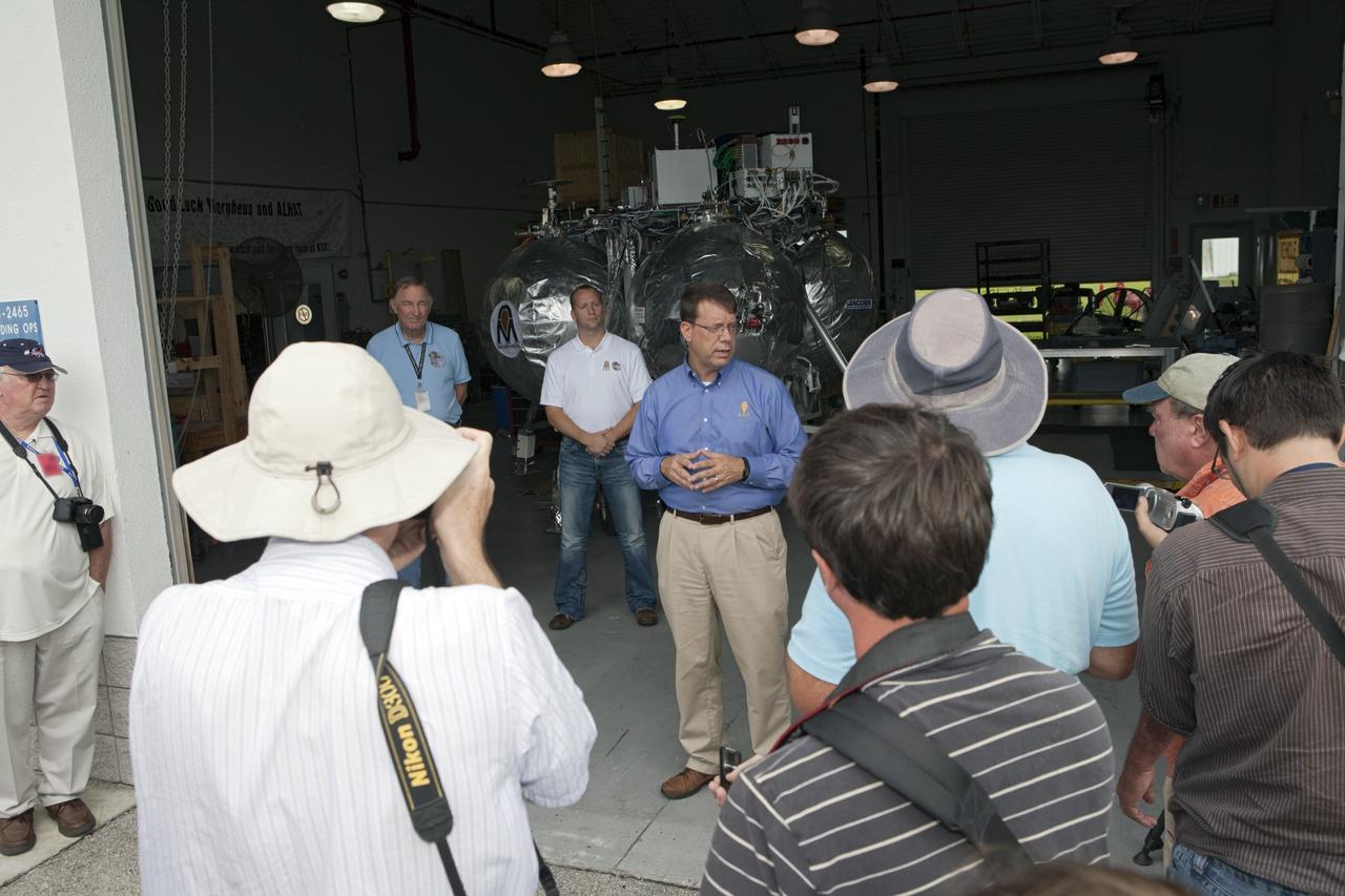 CAPE CANAVERAL, Fla. - At a hangar near the Shuttle Landing Facility, or SLF, at NASA’s Kennedy Space Center in Florida, members of the media view the Morpheus prototype lander and speak with Morpheus managers. In front is Gregory Gaddis, Kennedy Project Morpheus/ALHAT site manager. To his left, are Jon Olansen, Johnson Space Center Project Morpheus manager and Chirold Epp, JSC ALHAT project manager.    Testing of the prototype lander had been ongoing at NASA’s Johnson Space Center in Houston in preparation for its first free-flight test at Kennedy Space Center. The SLF will provide the lander with the kind of field necessary for realistic testing, complete with rocks, craters and hazards to avoid. Morpheus utilizes an autonomous landing and hazard avoidance technology, or ALHAT, payload that will allow it to navigate to clear landing sites amidst rocks, craters and other hazards during its descent. Project Morpheus is one of 20 small projects comprising the Advanced Exploration Systems, or AES, program in NASA’s Human Exploration and Operations Mission Directorate. AES projects pioneer new approaches for rapidly developing prototype systems, demonstrating key capabilities and validating operational concepts for future human missions beyond Earth orbit. For more information on Project Morpheus, visit http://morpheuslander.jsc.nasa.gov/.  Photo credit: NASA/Kim Shiflett