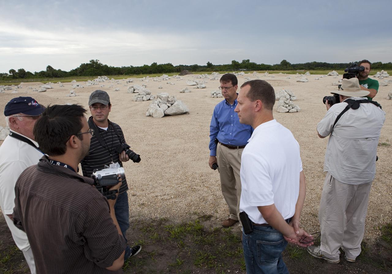 CAPE CANAVERAL, Fla. - At the Autonomous Landing and Hazard Avoidance Technology, or ALHAT, field at the north end of the Shuttle Landing Facility, or SLF, at NASA’s Kennedy Space Center in Florida, members of the media view the hazard field and speak with Morpheus managers. In the white shirt is Jon Olansen, Johnson Space Center Project Morpheus Manager. Behind Olansen is Gregory Gaddis, Kennedy Project Morpheus/ALHAT site manager.     Testing of the prototype lander had been ongoing at NASA’s Johnson Space Center in Houston in preparation for its first free-flight test at Kennedy Space Center. The SLF will provide the lander with the kind of field necessary for realistic testing, complete with rocks, craters and hazards to avoid. Morpheus utilizes an autonomous landing and hazard avoidance technology, or ALHAT, payload that will allow it to navigate to clear landing sites amidst rocks, craters and other hazards during its descent. Project Morpheus is one of 20 small projects comprising the Advanced Exploration Systems, or AES, program in NASA’s Human Exploration and Operations Mission Directorate. AES projects pioneer new approaches for rapidly developing prototype systems, demonstrating key capabilities and validating operational concepts for future human missions beyond Earth orbit. For more information on Project Morpheus, visit http://morpheuslander.jsc.nasa.gov/.  Photo credit: NASA/Kim Shiflett