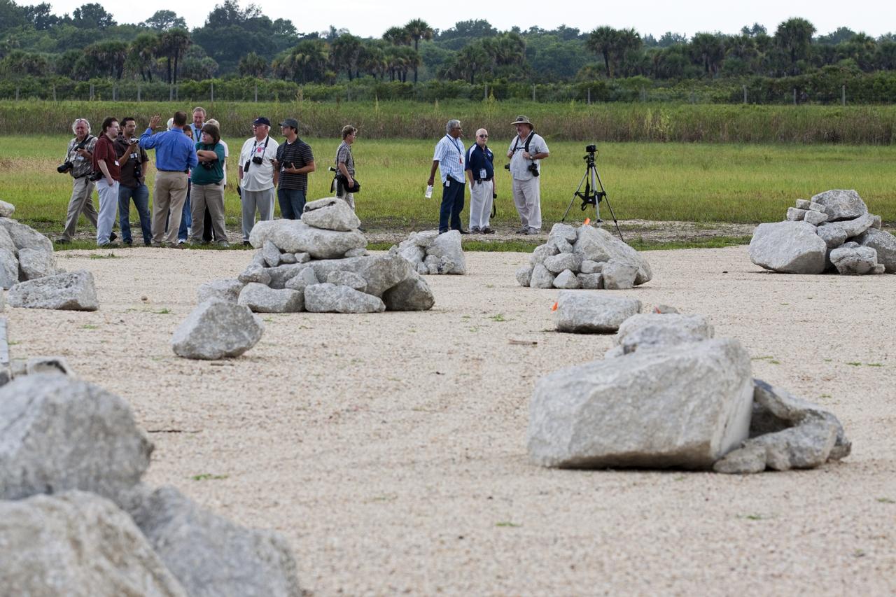 CAPE CANAVERAL, Fla. - At the Autonomous Landing and Hazard Avoidance Technology, or ALHAT, field at the north end of the Shuttle Landing Facility, or SLF, at NASA’s Kennedy Space Center in Florida, members of the media view the hazard field and speak with Morpheus managers. At left, in the blue shirt is Gregory Gaddis, Kennedy Project Morpheus/ALHAT site manager. Testing of the prototype lander had been ongoing at NASA’s Johnson Space Center in Houston in preparation for its first free-flight test at Kennedy Space Center. The SLF will provide the lander with the kind of field necessary for realistic testing, complete with rocks, craters and hazards to avoid. Morpheus utilizes an autonomous landing and hazard avoidance technology, or ALHAT, payload that will allow it to navigate to clear landing sites amidst rocks, craters and other hazards during its descent. Project Morpheus is one of 20 small projects comprising the Advanced Exploration Systems, or AES, program in NASA’s Human Exploration and Operations Mission Directorate. AES projects pioneer new approaches for rapidly developing prototype systems, demonstrating key capabilities and validating operational concepts for future human missions beyond Earth orbit. For more information on Project Morpheus, visit http://morpheuslander.jsc.nasa.gov/. Photo credit: NASA/Kim Shiflett