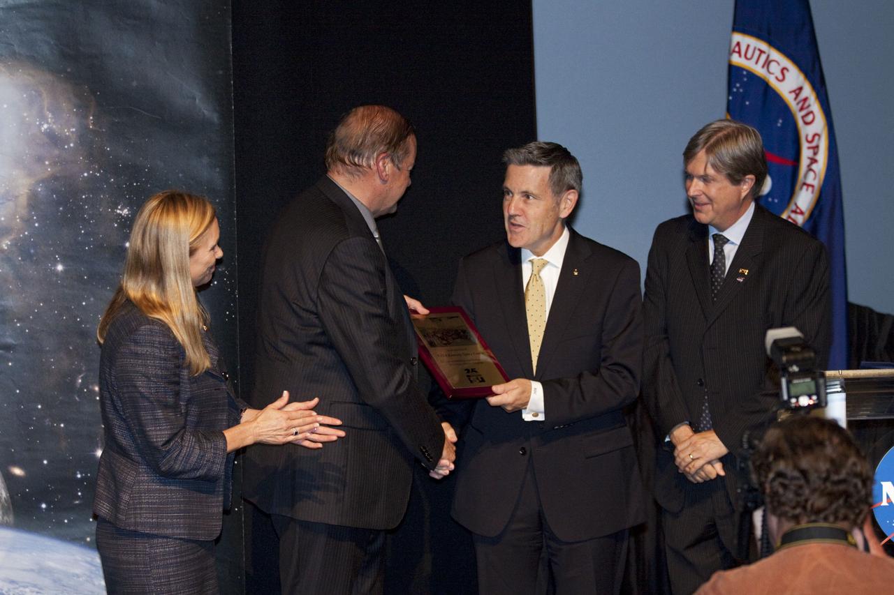 CAPE CANAVERAL, Fla. – Kennedy Space Center Director Robert Cabana, right-center, presents a commemorative plaque to, Dr. Walter Peeters, president of the International Space University. Looking on are Kennedy's Deputy Director Janet Petro and Gary Martin, 2012 director of Space Studies Program for the ISU. The presentation took place during ISU closing ceremonies at the Kennedy Space center Visitor Complex on Aug. 3, 2012.      The International Space University is a nine-week intensive course designed for post-graduate university students and professionals during the summer. The program is hosted by a different country each year, providing a unique educational experience for participants from around the world. NASA Kennedy Space Center and the Florida Institute of Technology co-hosted this year's event which ran from June 4 to Aug. 3. There were about 125 participants representing 31 countries. For more information, visit http://www.isunet.edu Photo credit: NASA/Kim Shiflett