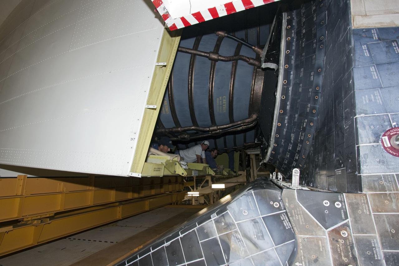 CAPE CANAVERAL, Fla. – In Orbiter Processing Facility Bay 2 at NASA’s Kennedy Space Center in Florida, United Space Alliance technicians monitor progress as the tail cone moves into position for attachment to the space shuttle Endeavour. The tail cone covers the engines in the aft providing aerodynamic stability during the cross-country ferry flight.      The work is part of Transition and Retirement of the remaining space shuttles, Endeavour and Atlantis. Endeavour is being prepared for public display at the California Science Center in Los Angeles. Its ferry flight to California is targeted for mid-September. Endeavour was the last space shuttle added to NASA’s orbiter fleet. Over the course of its 19-year career, Endeavour spent 299 days in space during 25 missions. For more information, visit http://www.nasa.gov/transition Photo credit: NASA/ Jim Grossmann