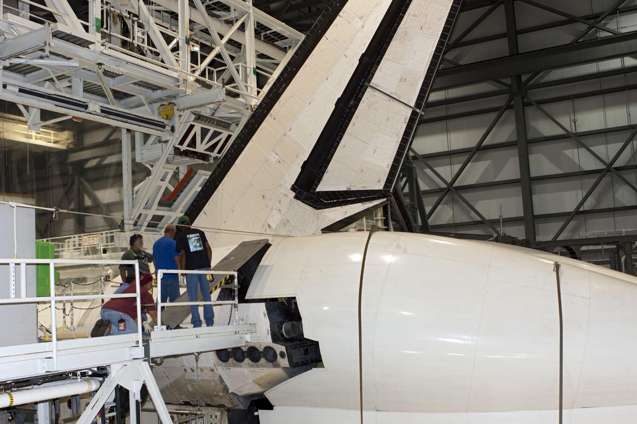 CAPE CANAVERAL, Fla. – In Orbiter Processing Facility Bay 2 at NASA’s Kennedy Space Center in Florida, United Space Alliance technicians monitor progress as the tail cone is fitted to the space shuttle Endeavour. The tail cone covers the engines in the aft providing aerodynamic stability during the cross-country ferry flight.      The work is part of Transition and Retirement of the remaining space shuttles, Endeavour and Atlantis. Endeavour is being prepared for public display at the California Science Center in Los Angeles. Its ferry flight to California is targeted for mid-September. Endeavour was the last space shuttle added to NASA’s orbiter fleet. Over the course of its 19-year career, Endeavour spent 299 days in space during 25 missions. For more information, visit http://www.nasa.gov/transition Photo credit: NASA/ Jim Grossmann